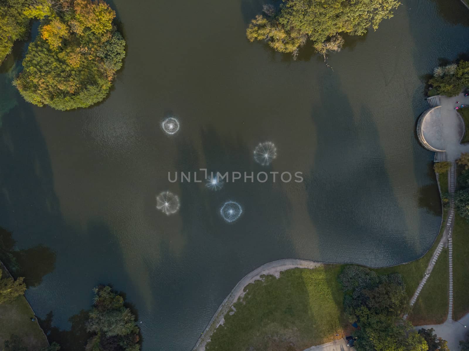 Aerial top down view to small fountains at center of lake in Wroclaw south park