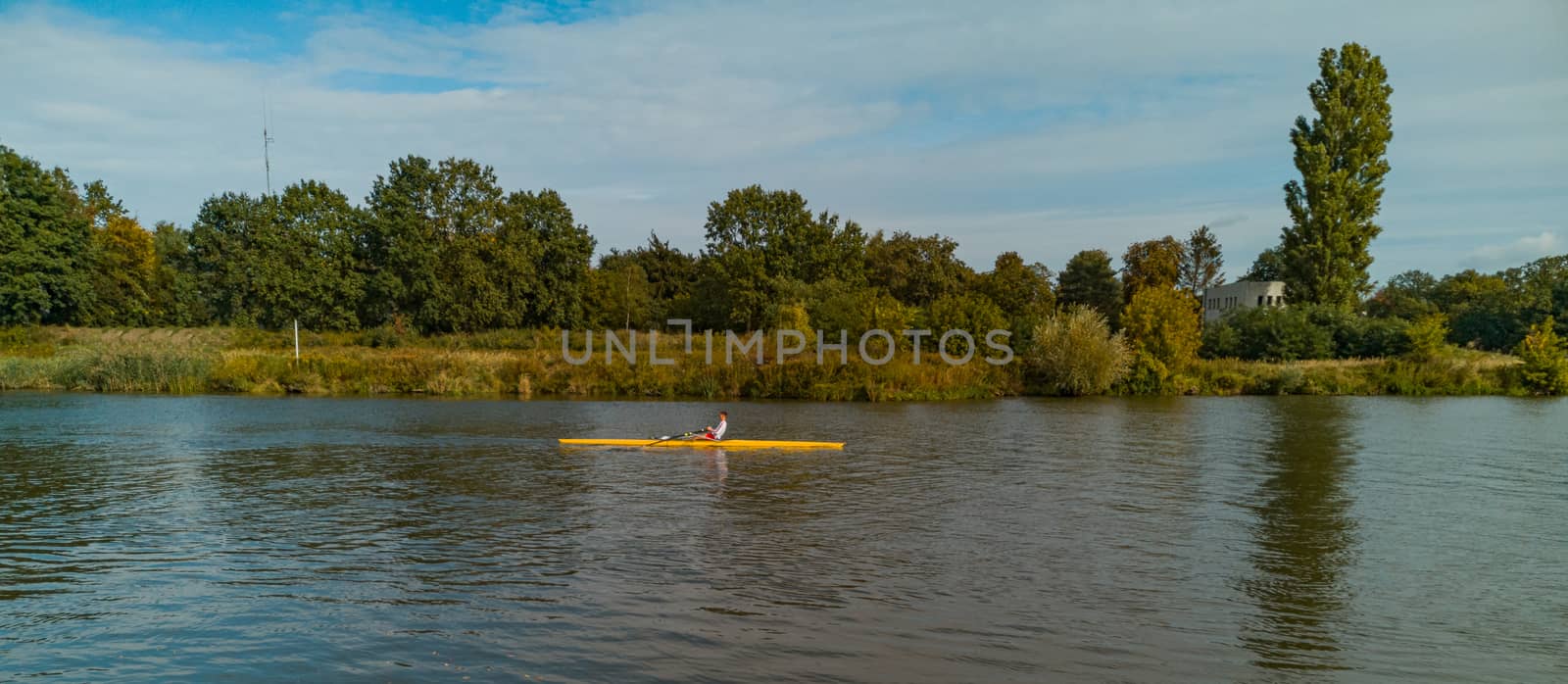 Man swimming on yellow kayak on Odra river