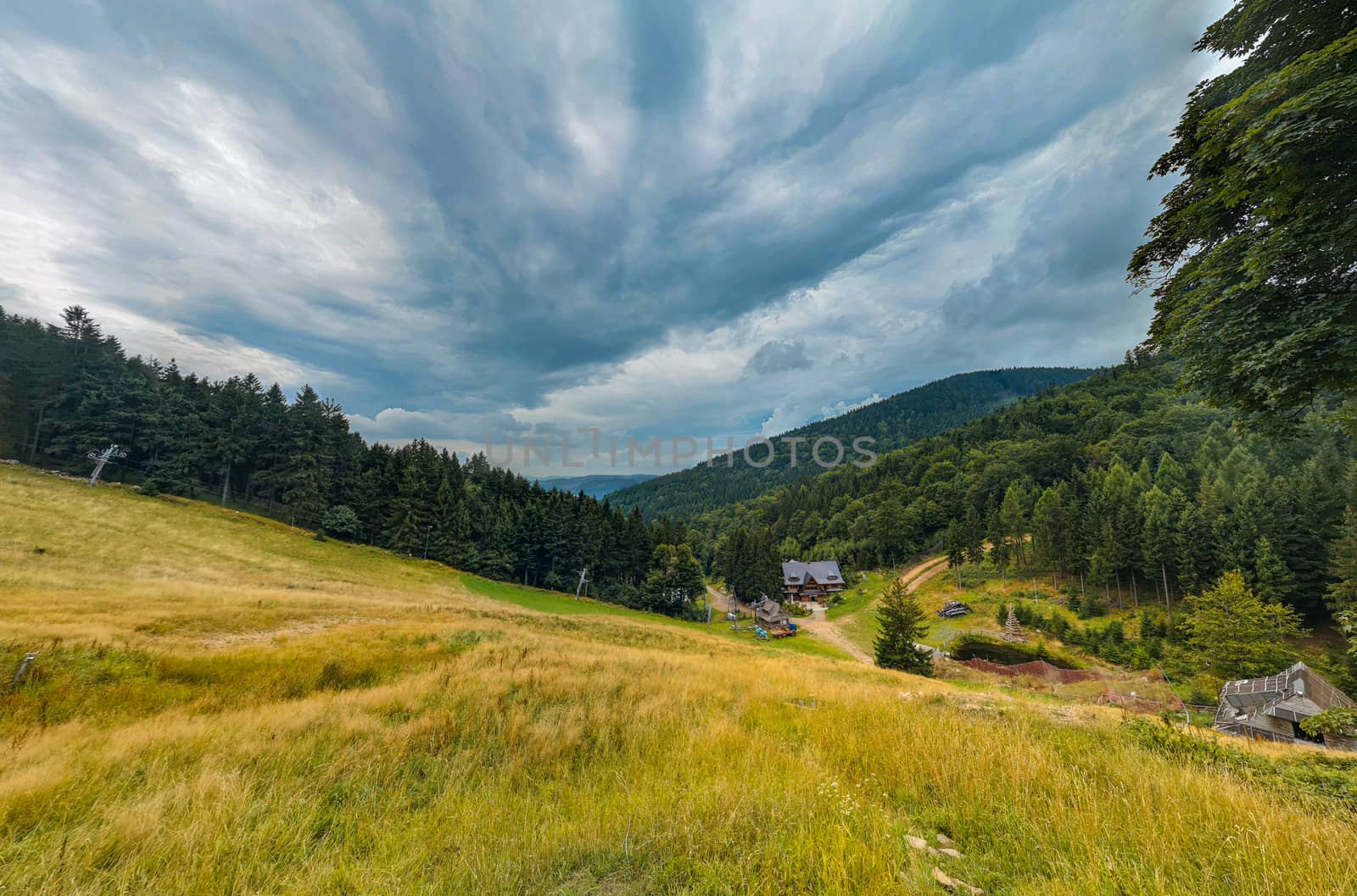 Small Wooden shelter in Owl Mountains between bushes and forest under ski slope