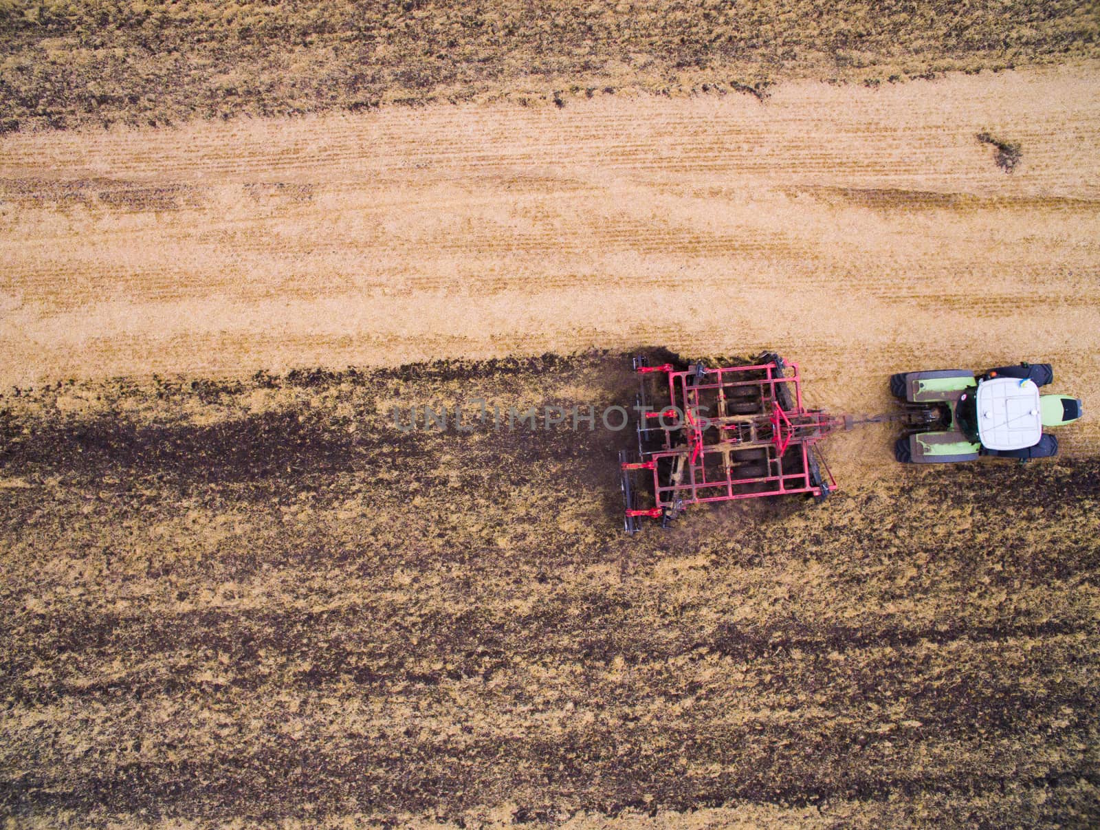 Harvesting in the field. Aerial view. Land cultivation with a tractor by TrEKone