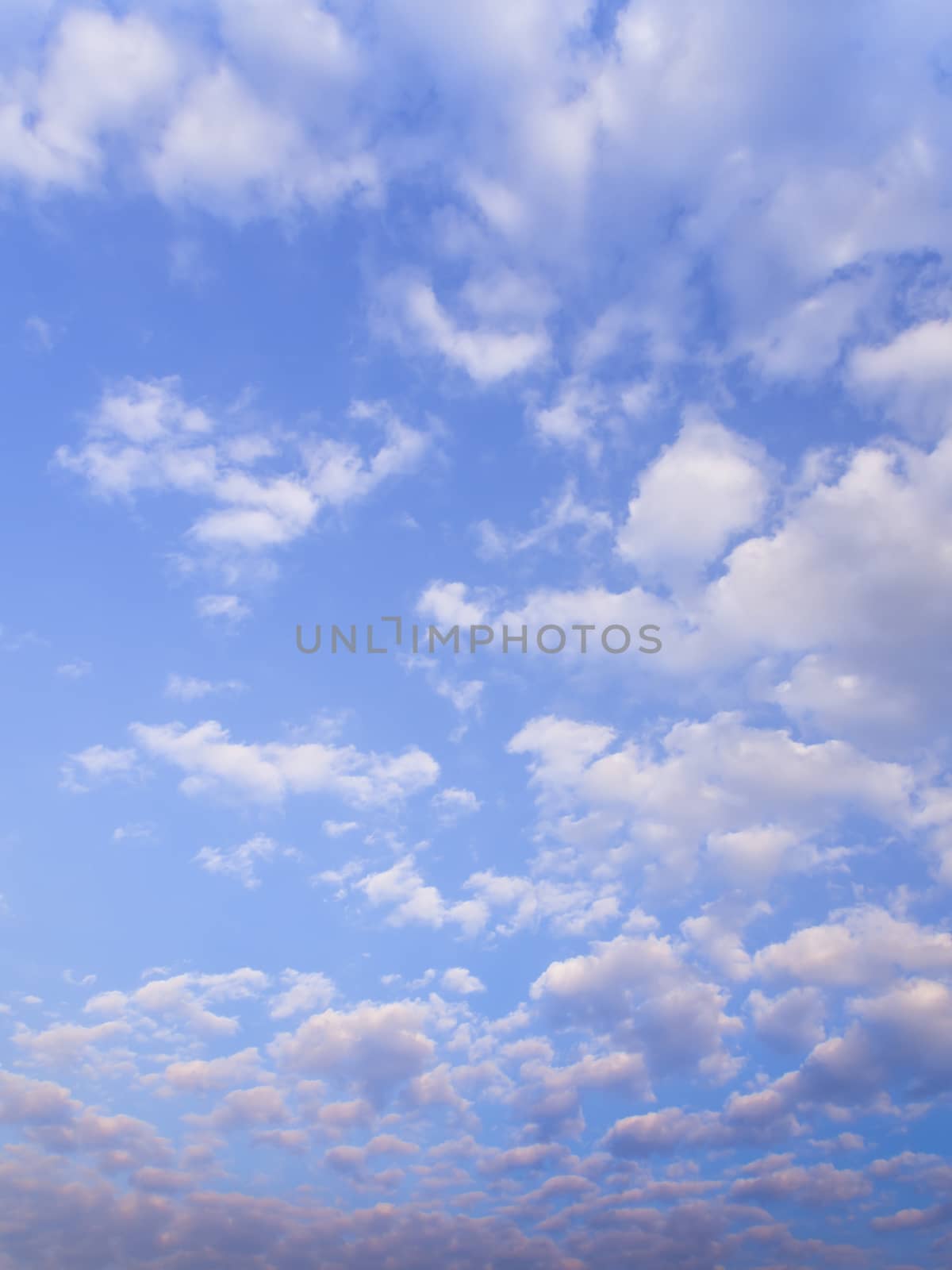 White fluffy clouds in the blue sky with morning light from the sunrise