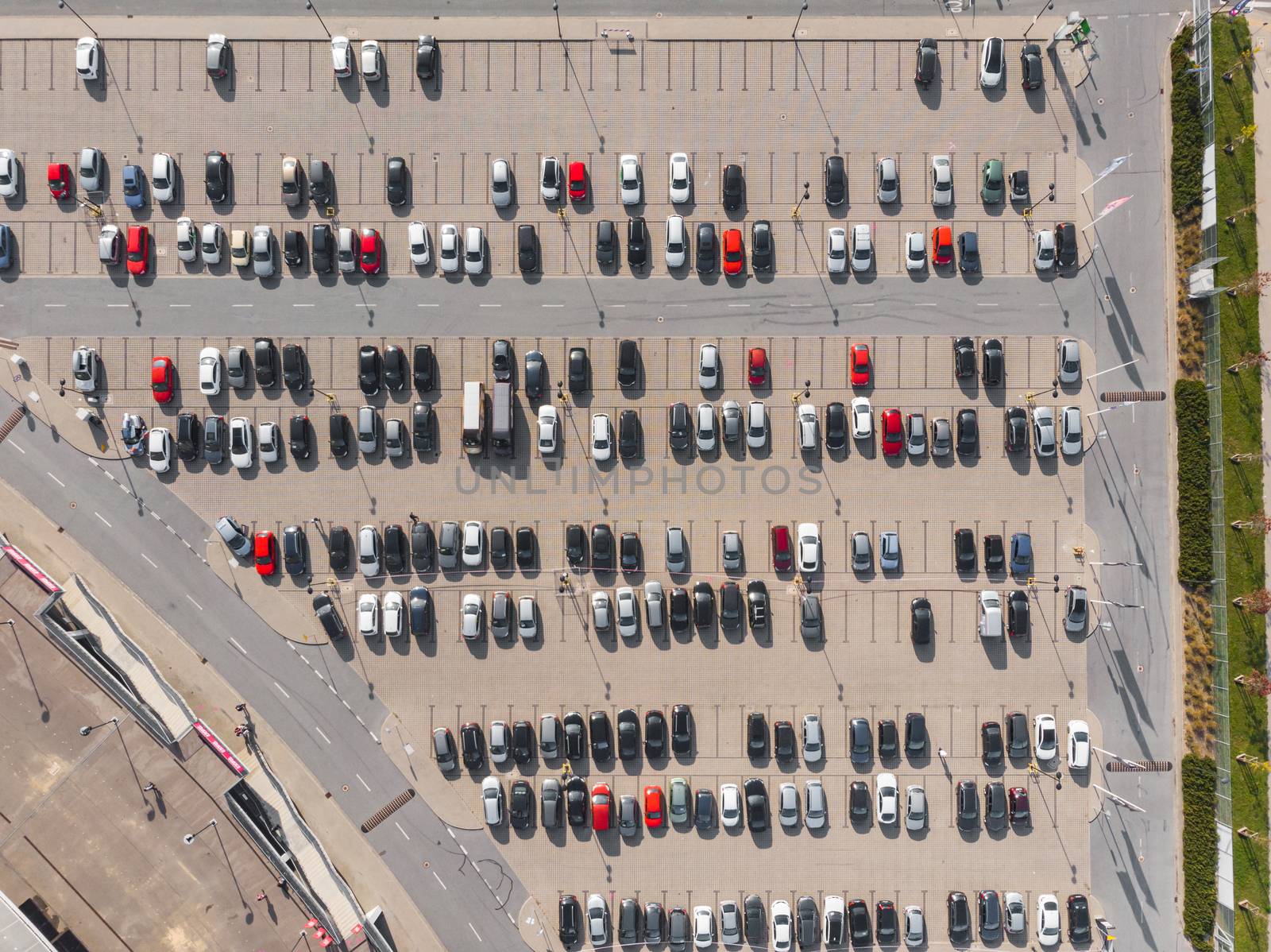 Aerial top down view to parking full of cars with isolated red cars