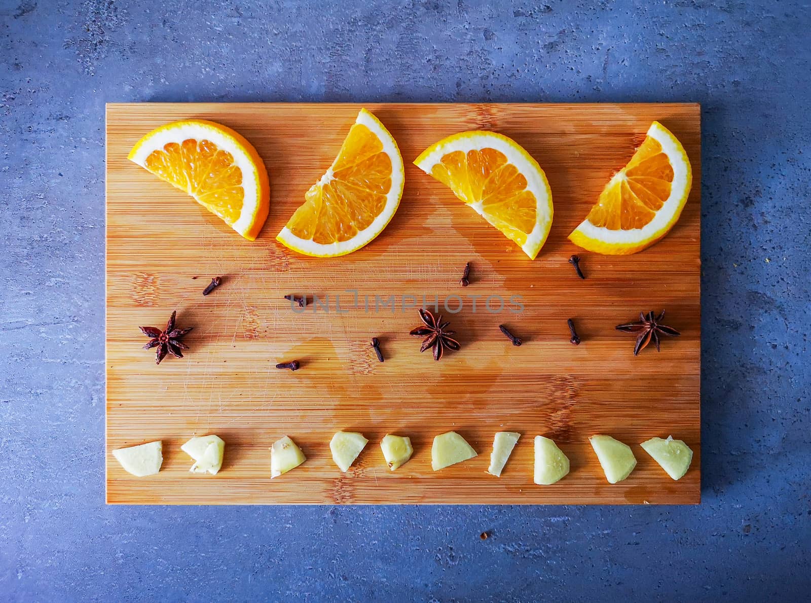 Oranges cloves anise ginger on wooden board as ingredients for mulled wine or beer