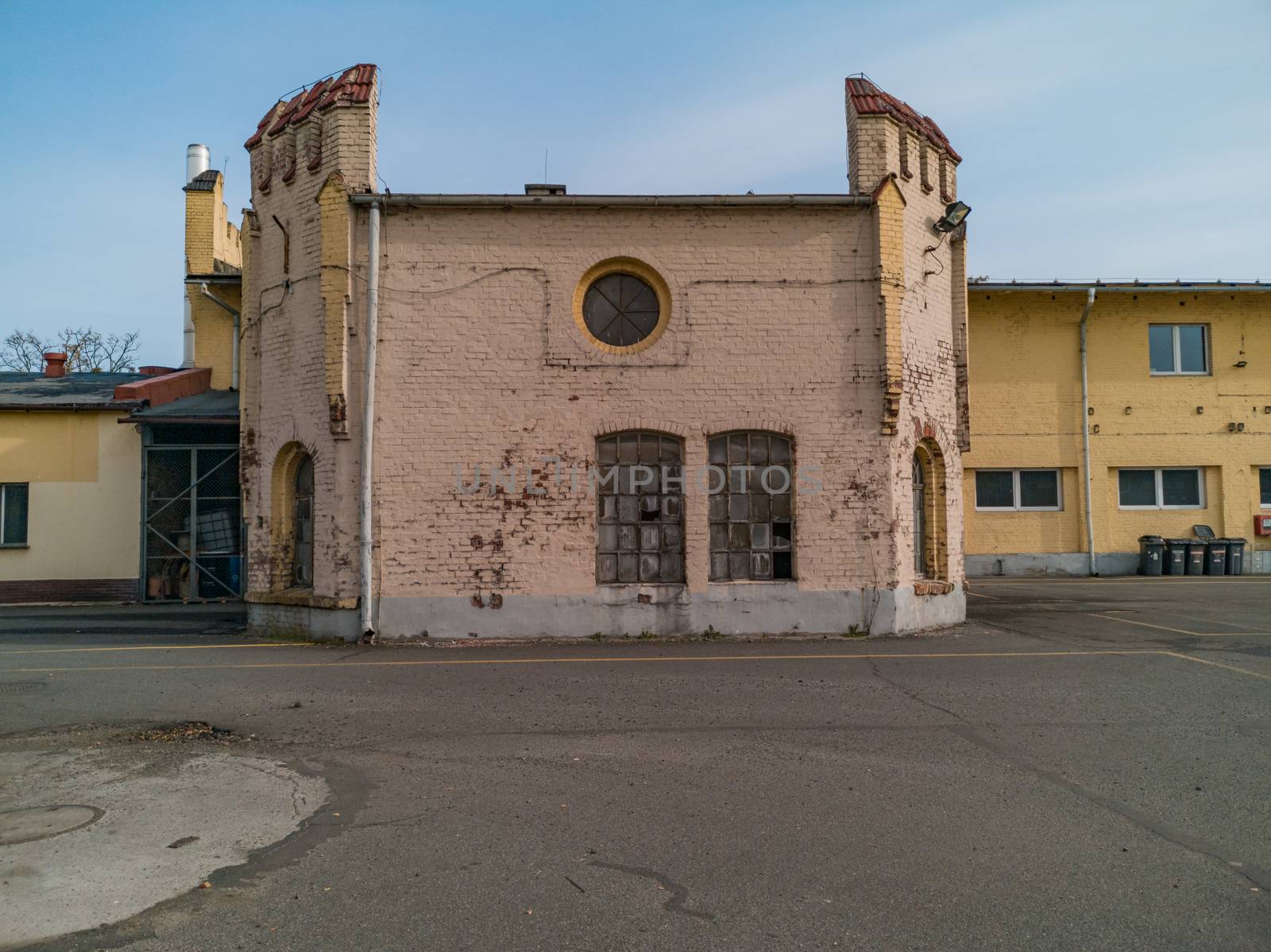 Ruins of old building with broken windows on parking for buses