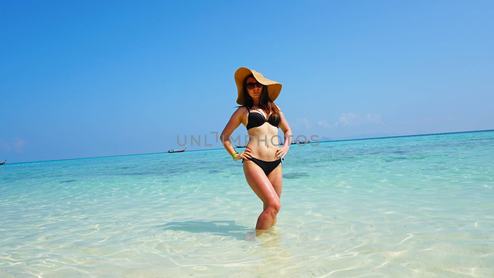 The girl in the hat and swimsuit on the beach. by Passcal