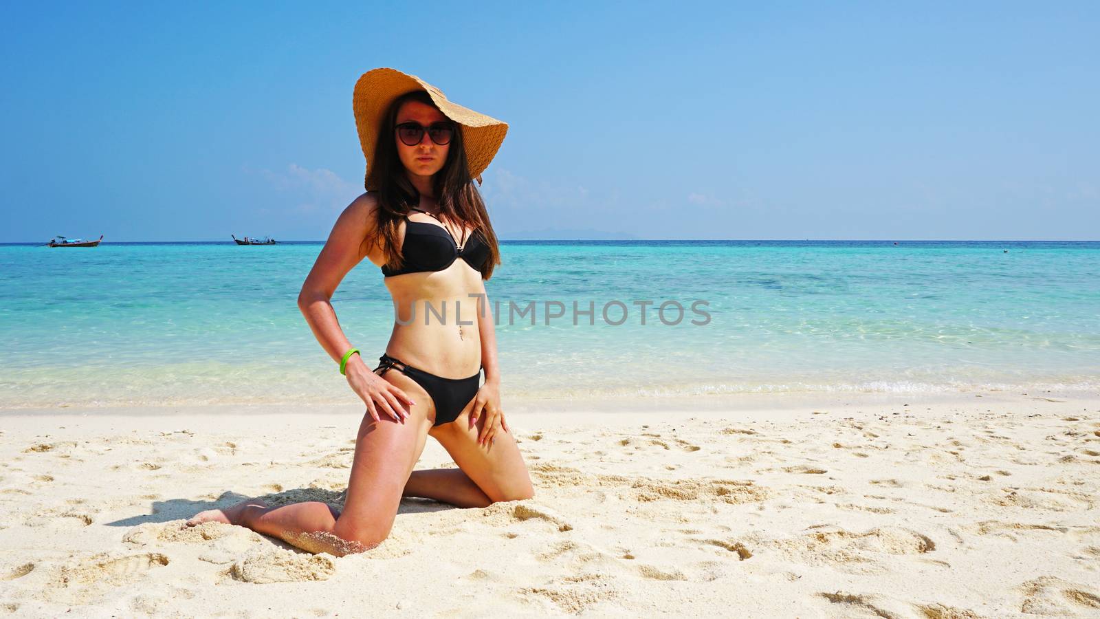 The girl in the hat and swimsuit on the beach. by Passcal