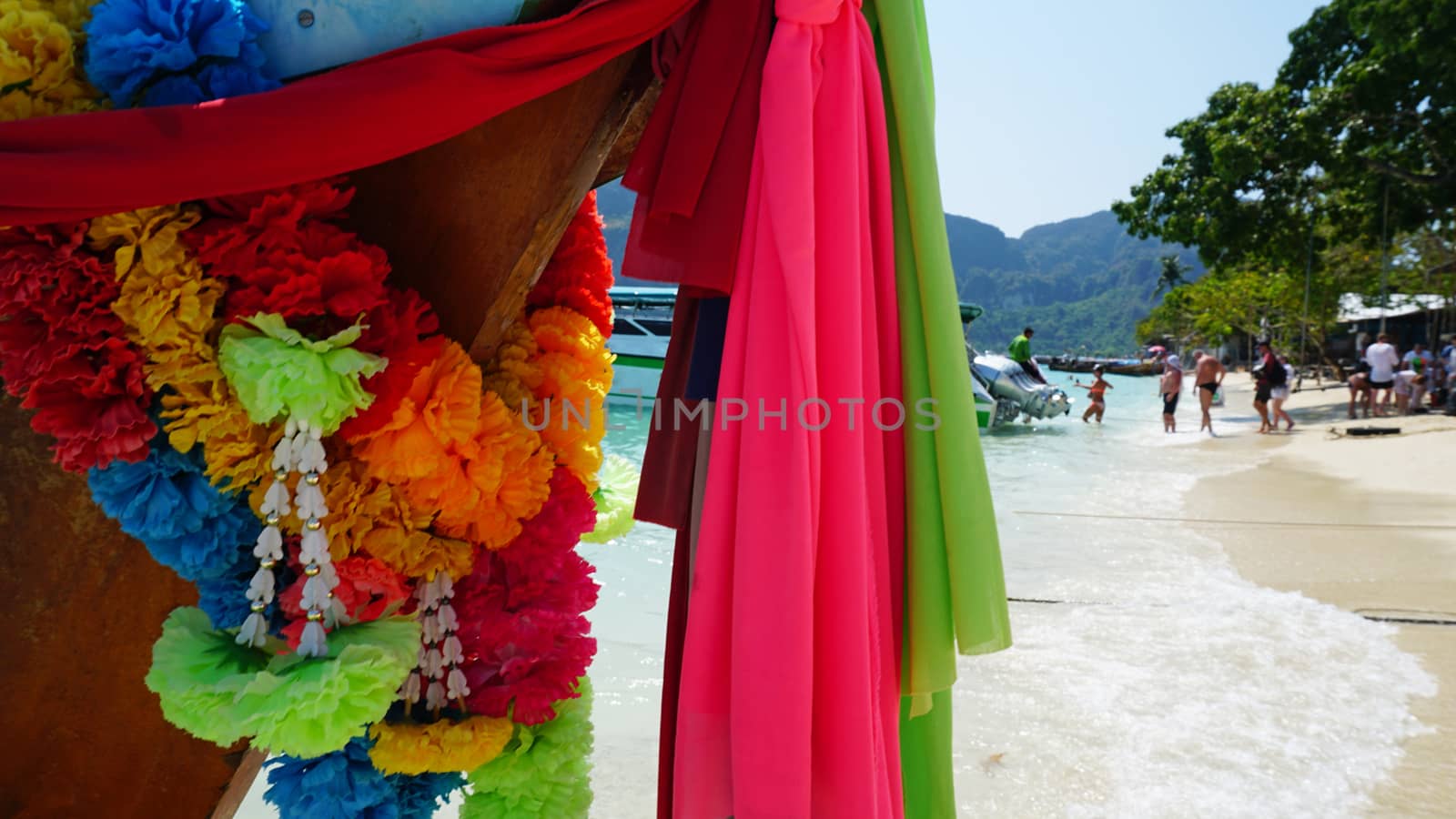 Sea long-tailed boats. Traditional Thai boats. Bright colored ribbons. Turquoise, blue, clear water. White sand on the beach. Holiday boat. A small wave. Travel to Asia. The Island Of Phi Phi Don.