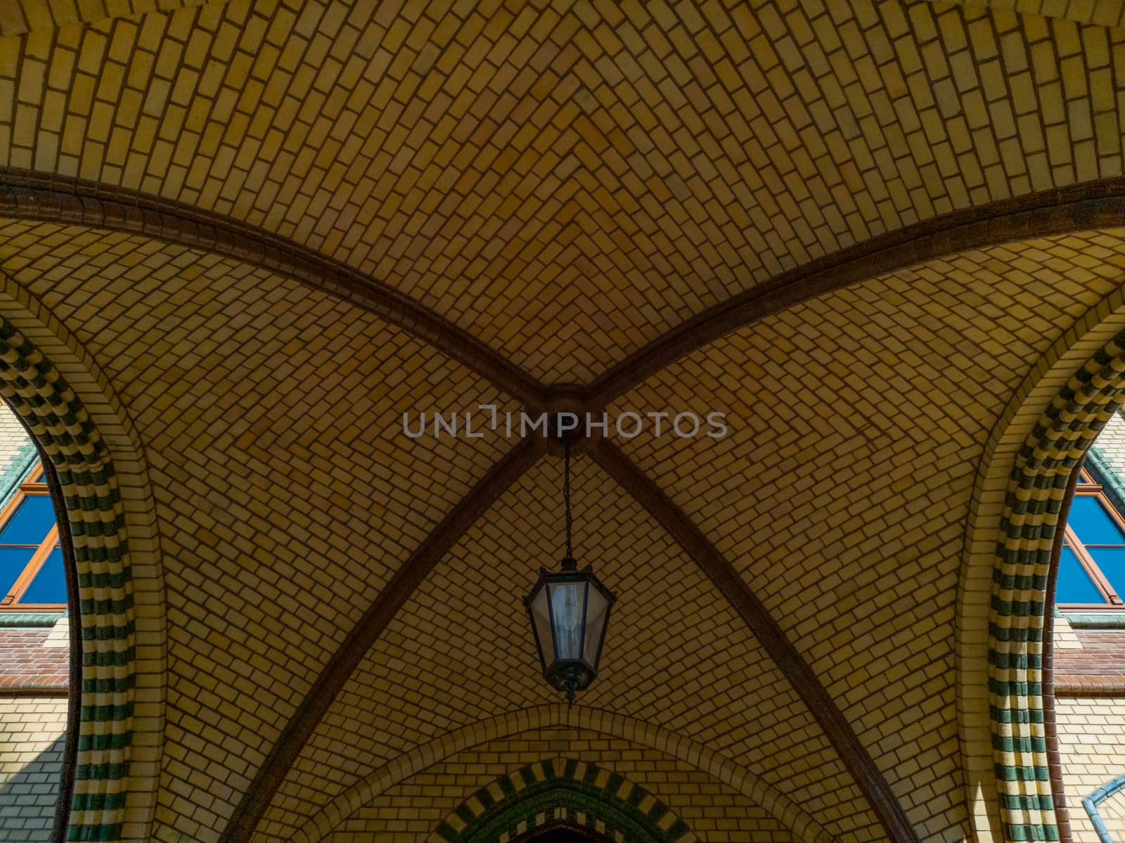 Old brick dome with hanging lamp in front of entrance to building by Wierzchu