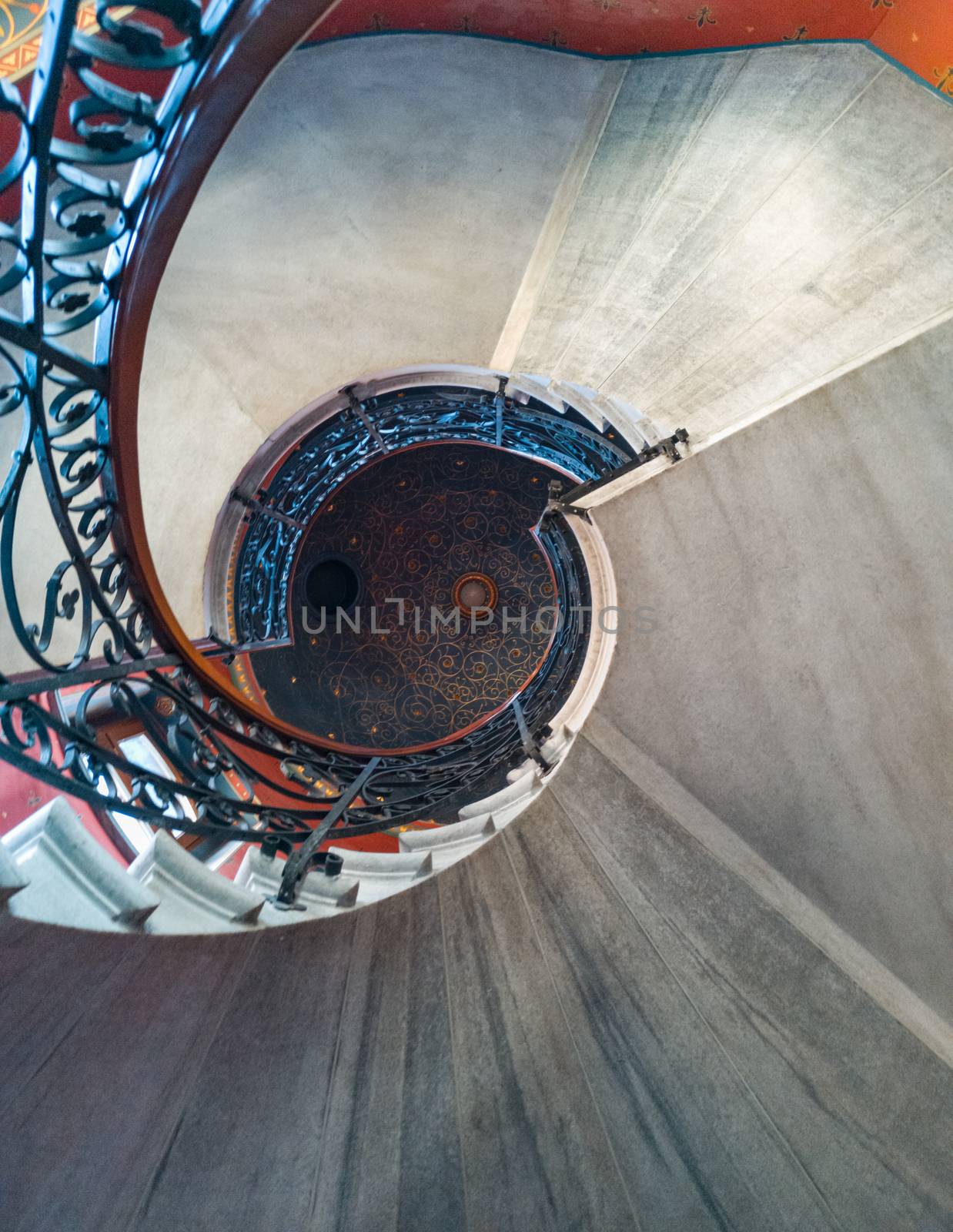 Upward view to old spiral staircase with pattern on ceiling by Wierzchu