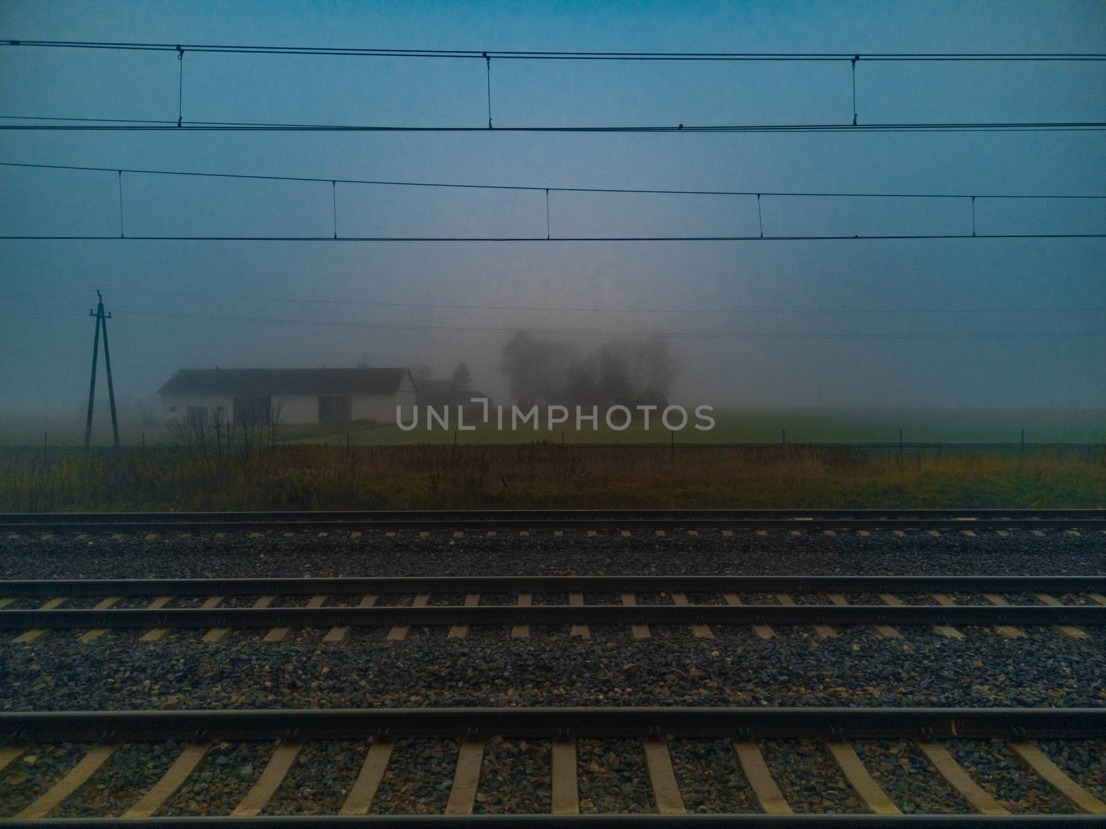 Morning fog over train rails and small barn by Wierzchu