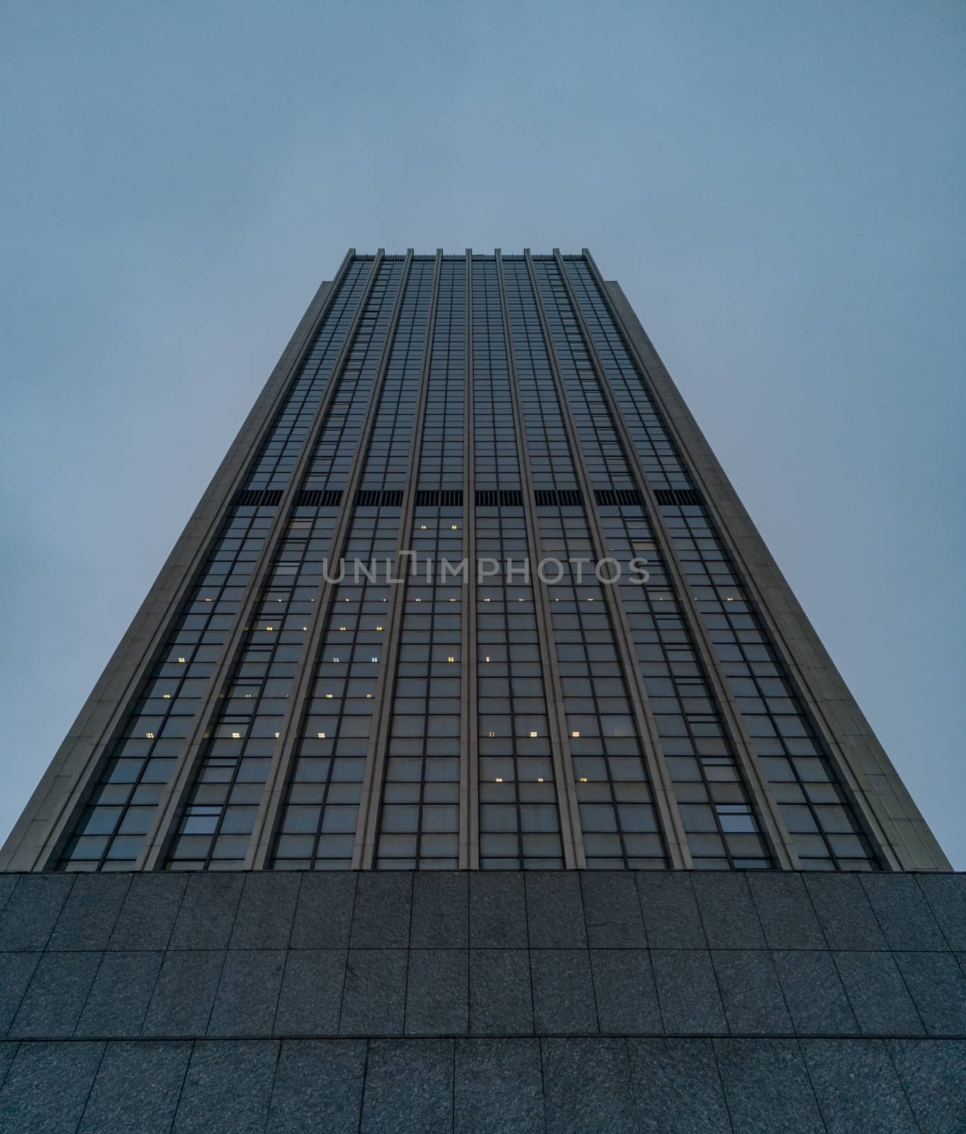 Upward view to high skyscraper full of offices 