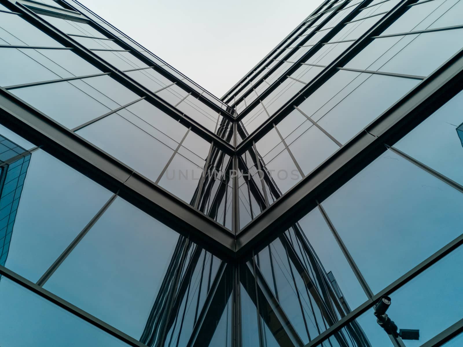 Upward view to reflections in corner of modern corporate building