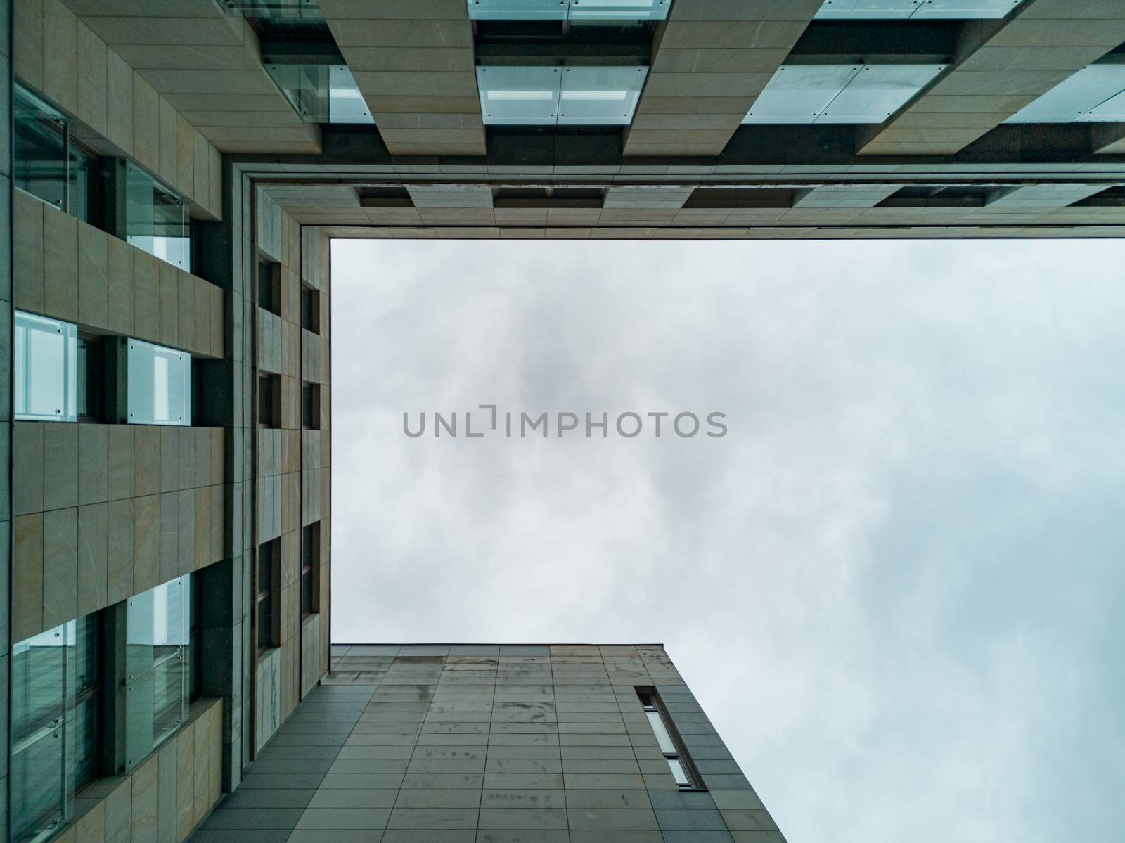 Upward view to modern marble and concrete corporate building by Wierzchu