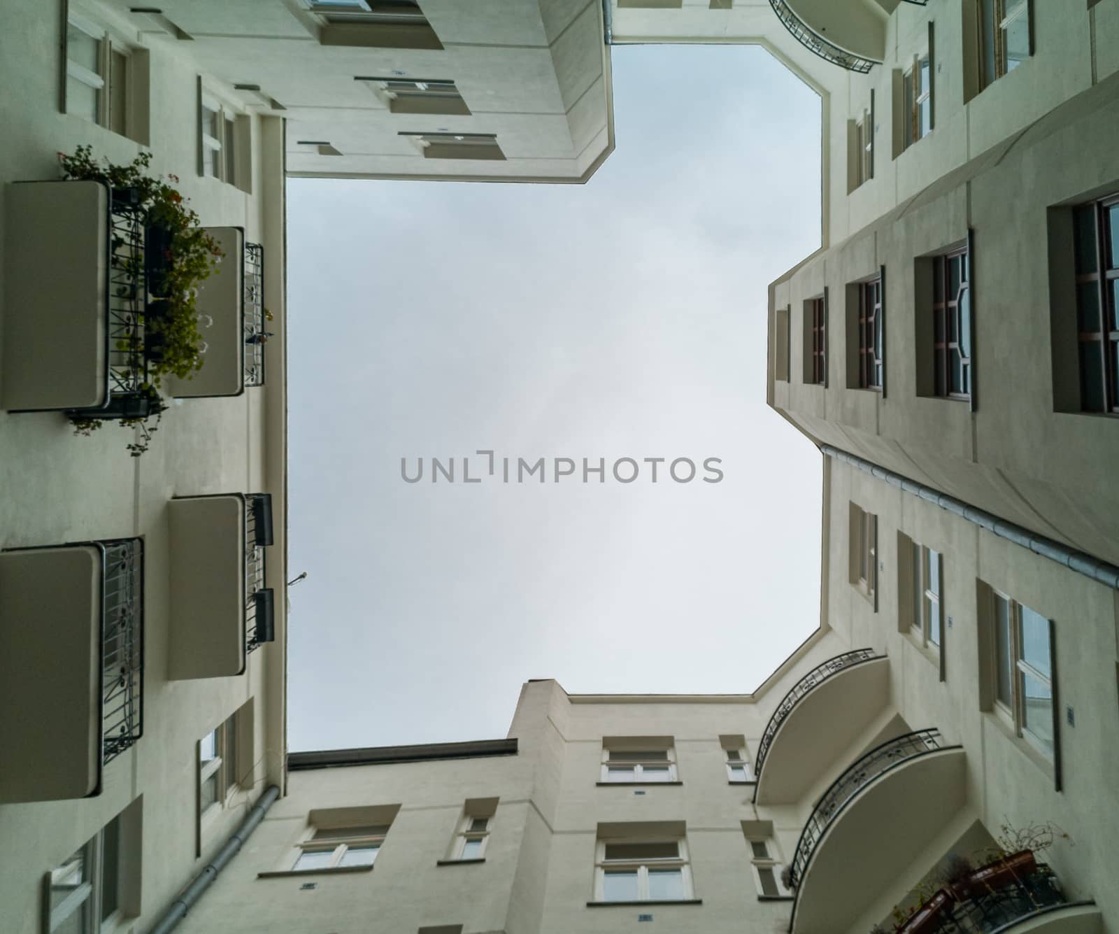 Upward view to building well in small square with old tenement house around by Wierzchu