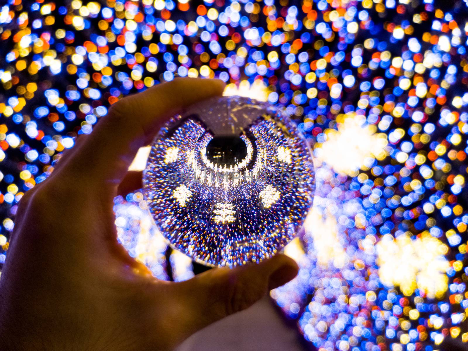 Round colorful christmas tunnel made of christmas lights reflected in crystal glassy lensball by Wierzchu