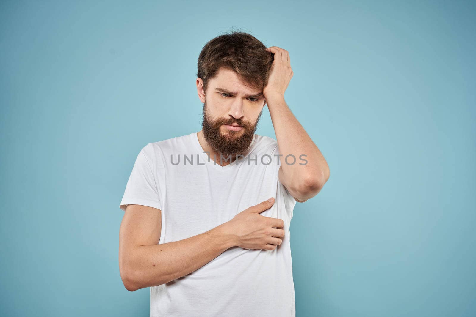 Man in white t-shirt lifestyle studio emotions facial expression blue isolated background. High quality photo