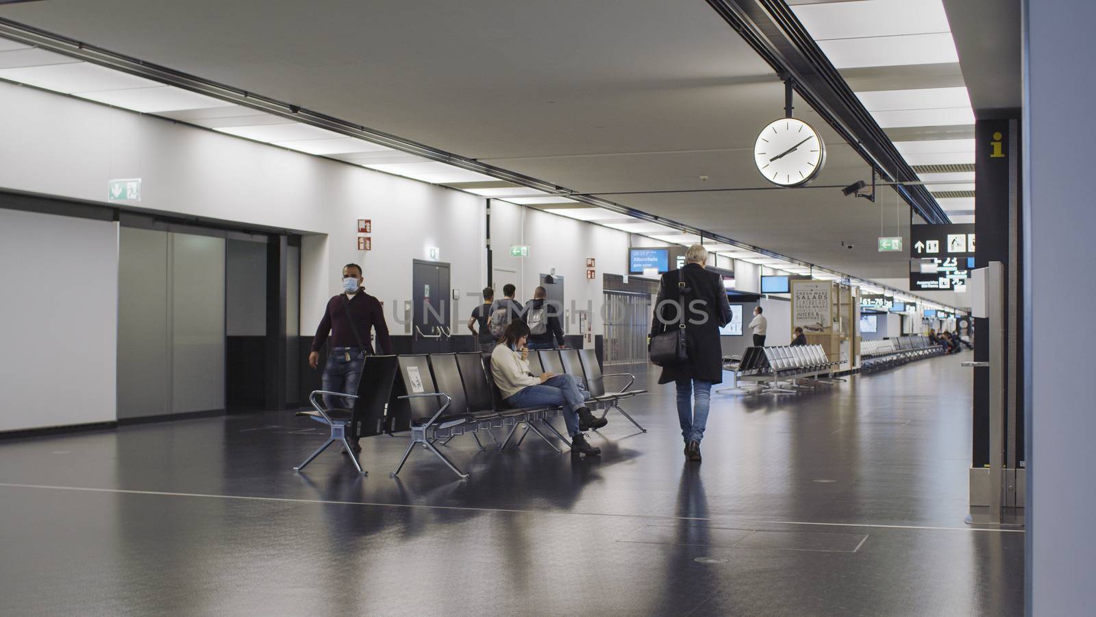 Vienna, Vienna/Austria - November 2nd 2020: Passengers waiting at Vienna airport. Only a few people travelling and a lot of closed gates.