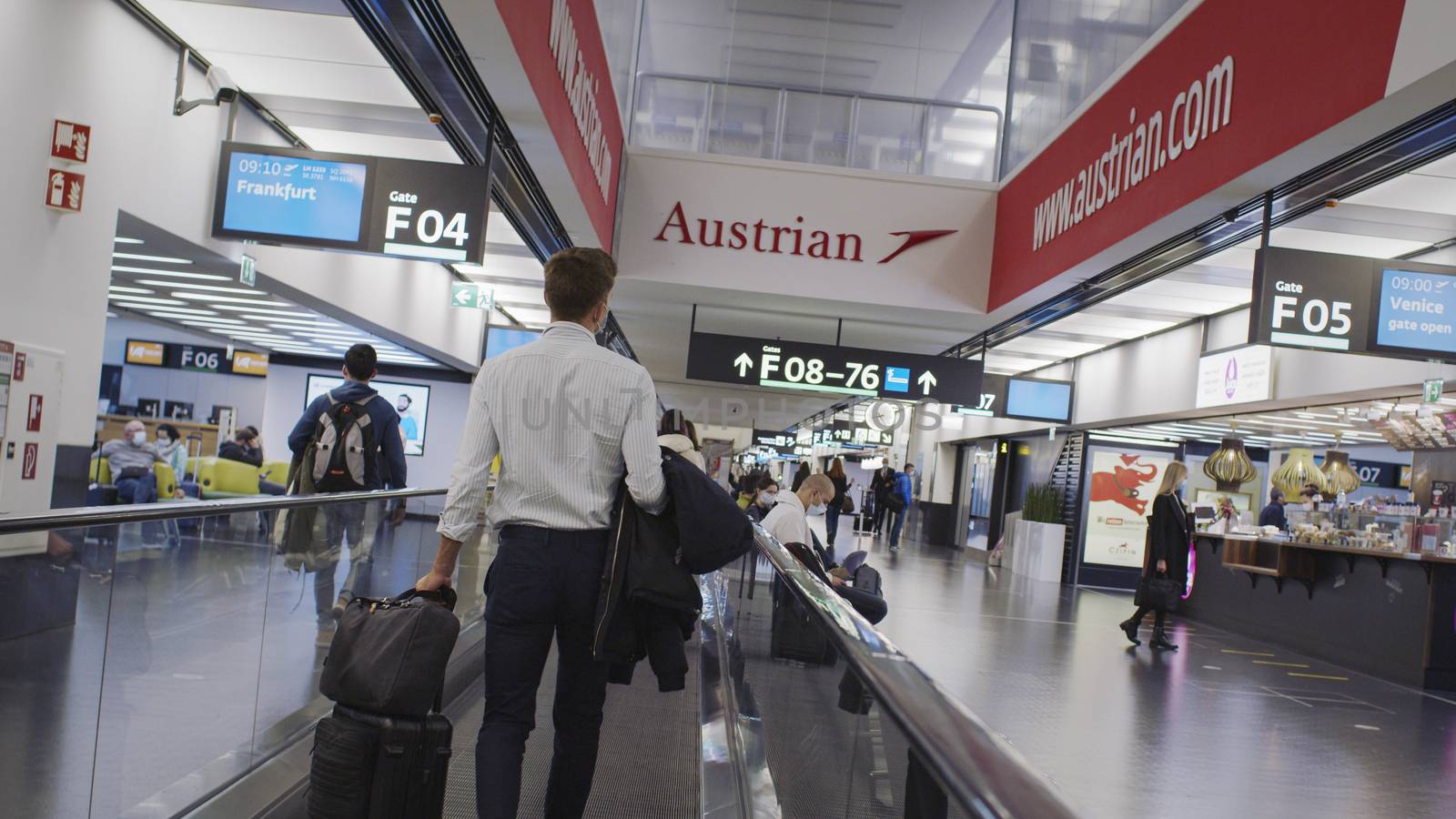 Vienna, Vienna/Austria - November 2nd 2020: Passengers walking to departure gates at Vienna airport. Only a few people travelling and a lot of closed gates.