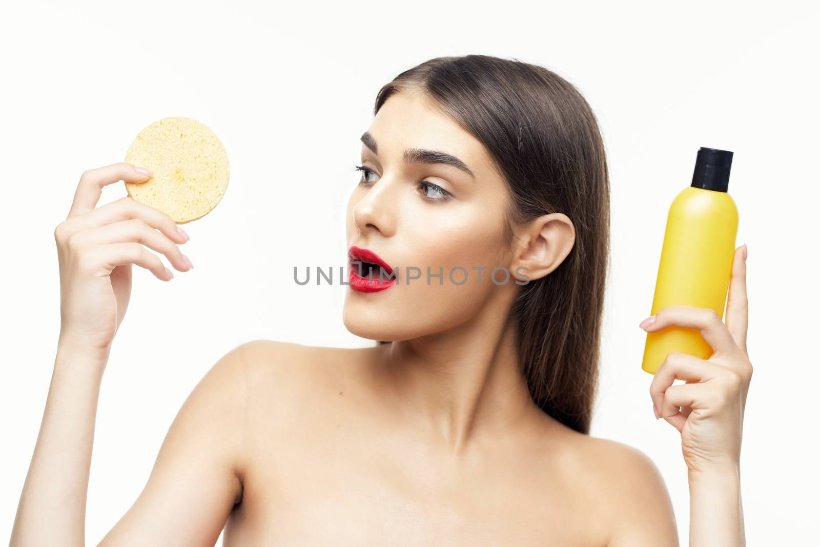 beautiful woman with a jar of lotion and a soft sponge in her hand