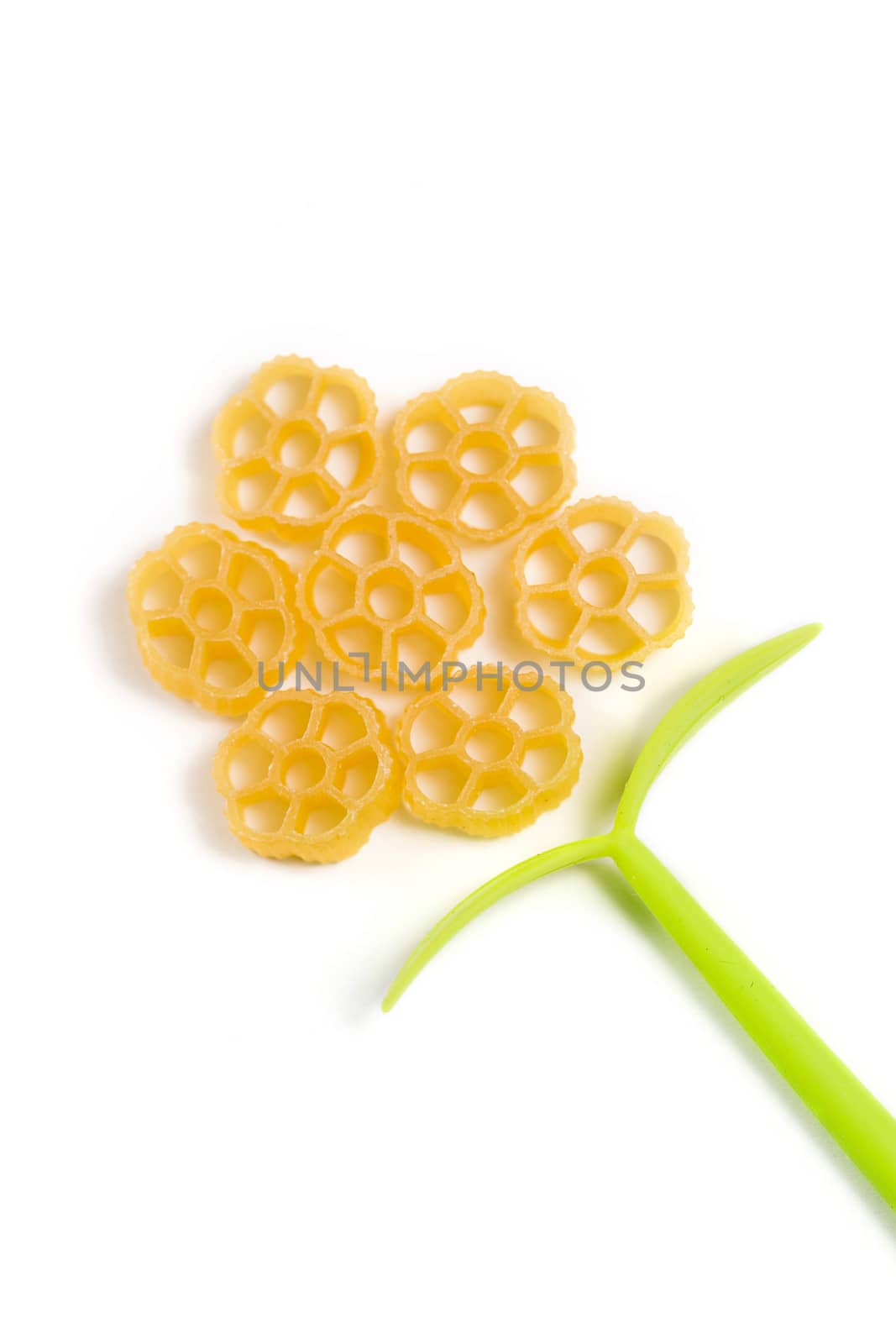 Flower shape made of raw Italian pasta isolated on white background by galinasharapova