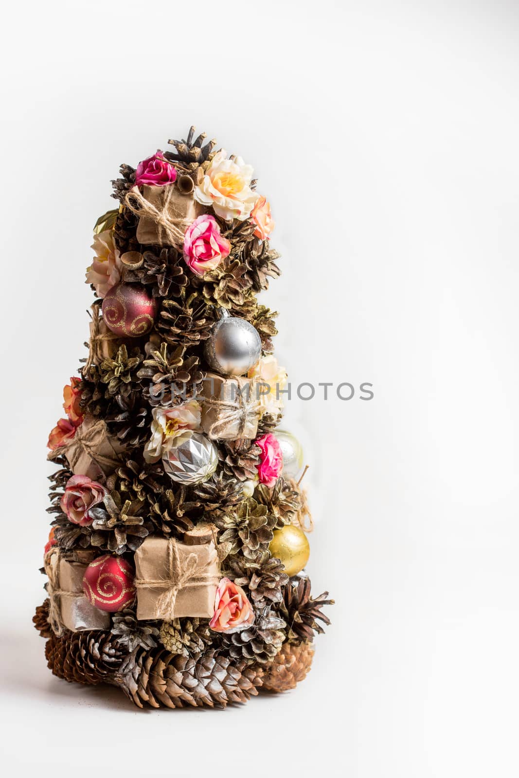 Christmas homemade fir tree in rustic style made pine cones, nuts, toys isolated by galinasharapova