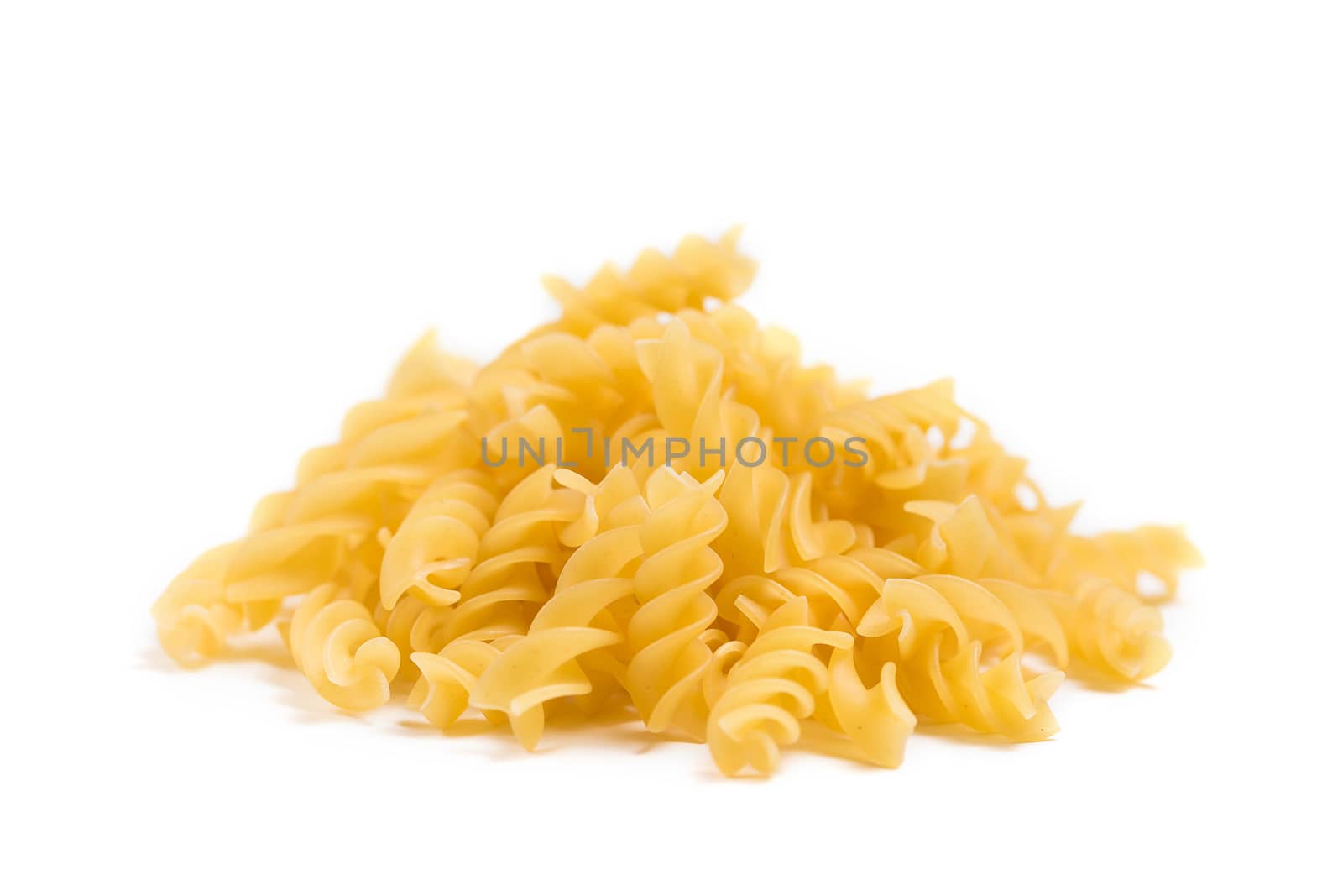 Raw Italian pasta in a heap on the table isolated on white background by galinasharapova