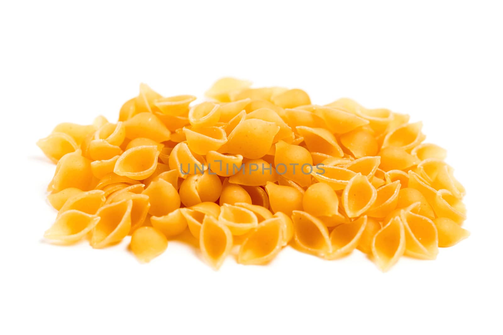 Raw Italian pasta in a heap on the table isolated on white background by galinasharapova