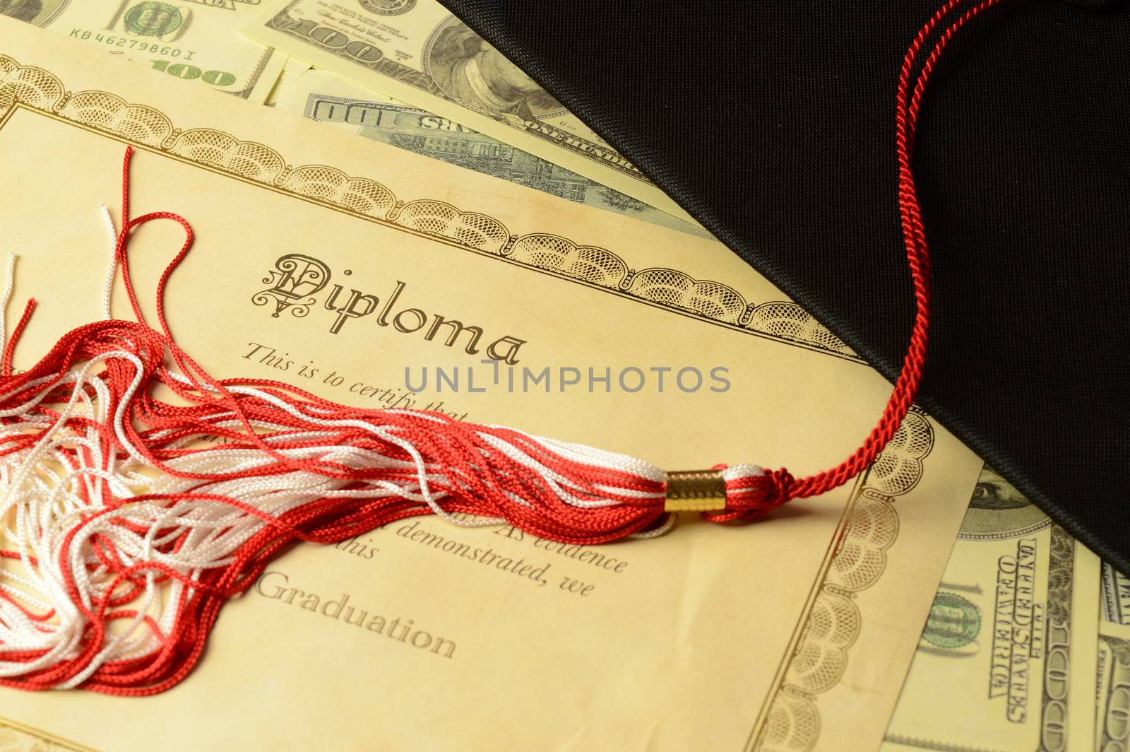 A closeup of a diploma certificate with a mortarboard and some American banknotes for the education theme still life.