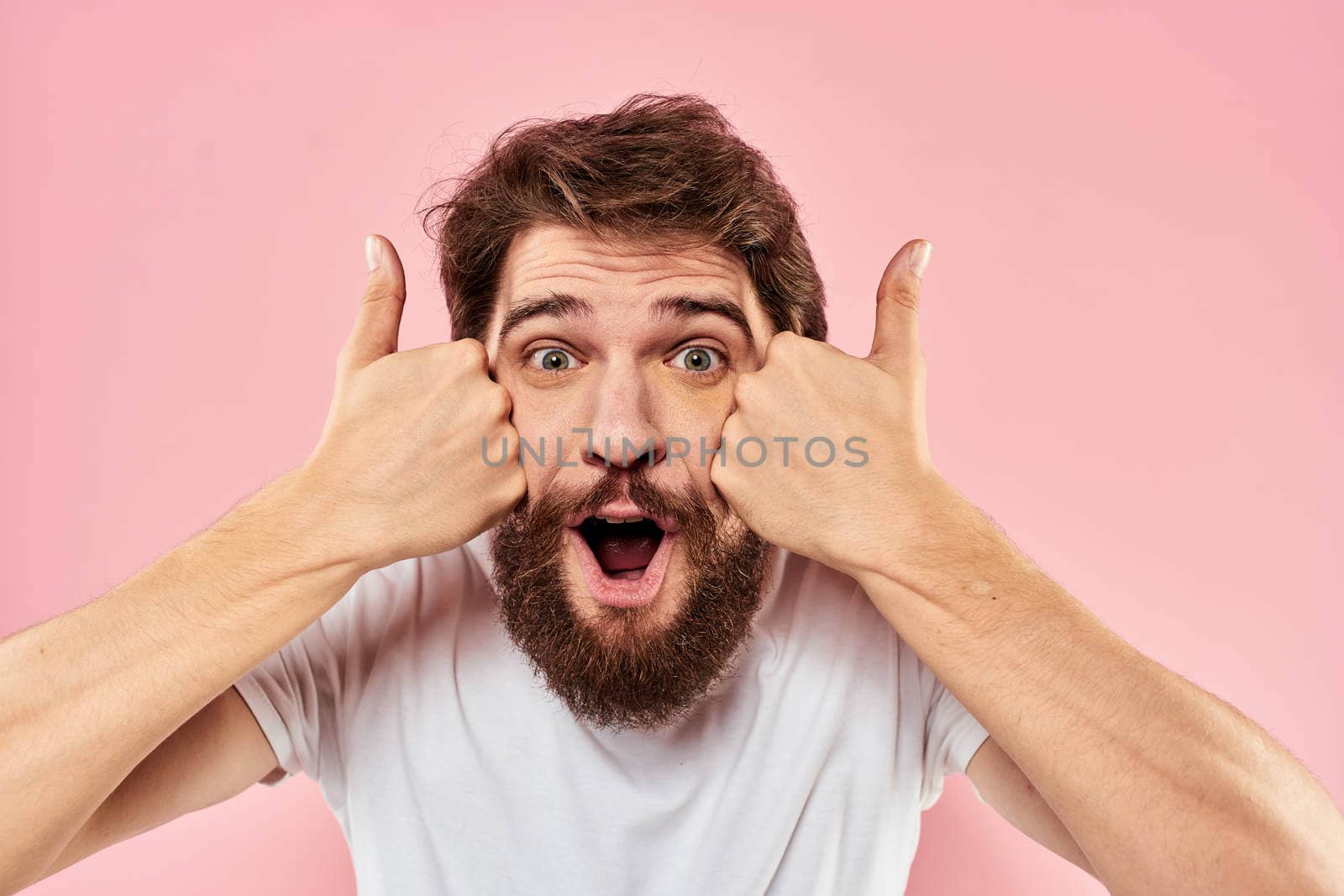 Bearded man white t-shirt cropped view lifestyle studio pink background. High quality photo