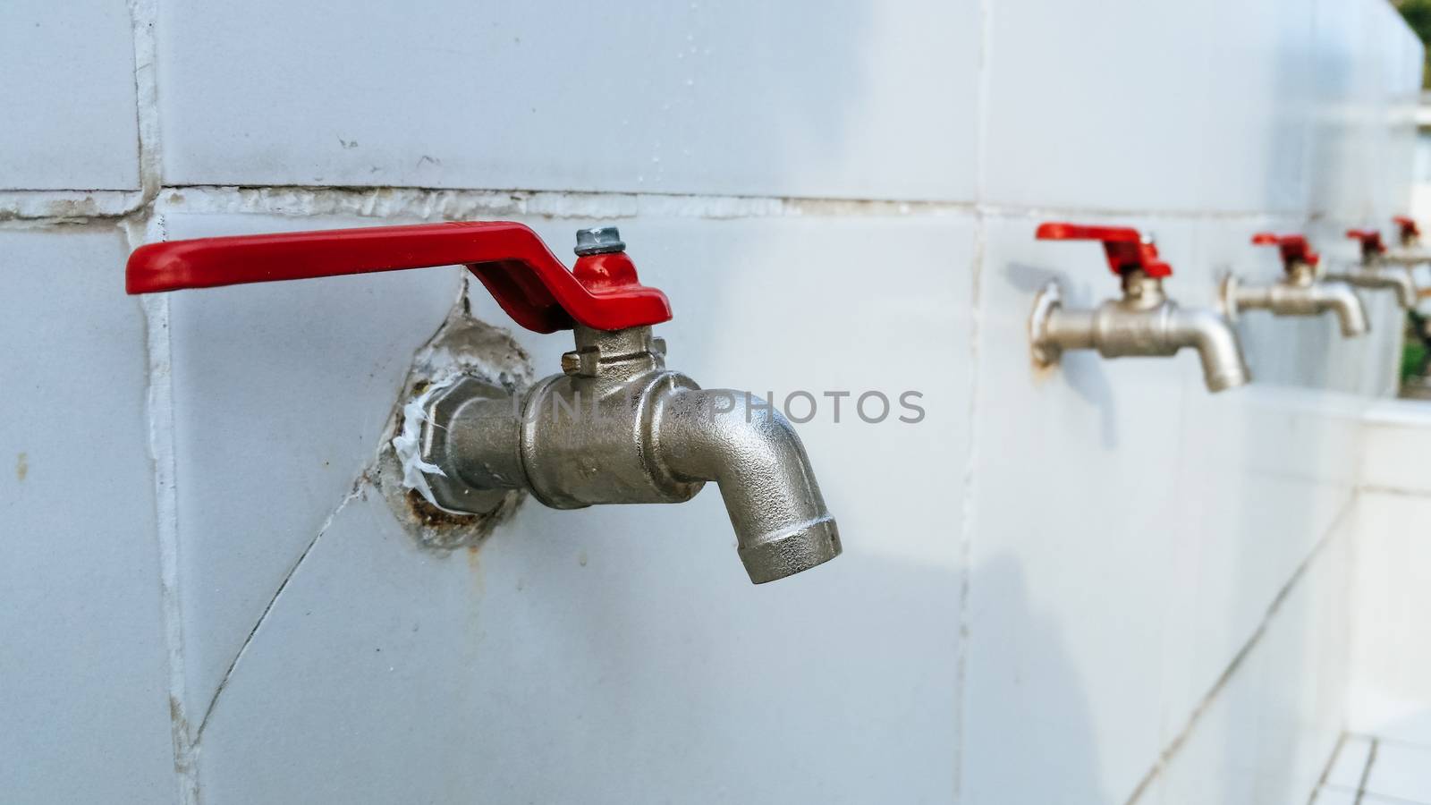Steel spout installed on a wall with tile