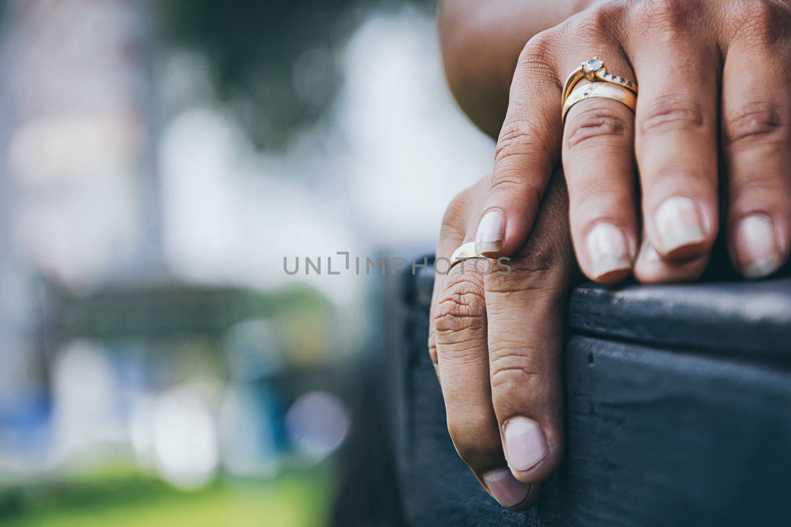 Hands of a couple with rings on park background