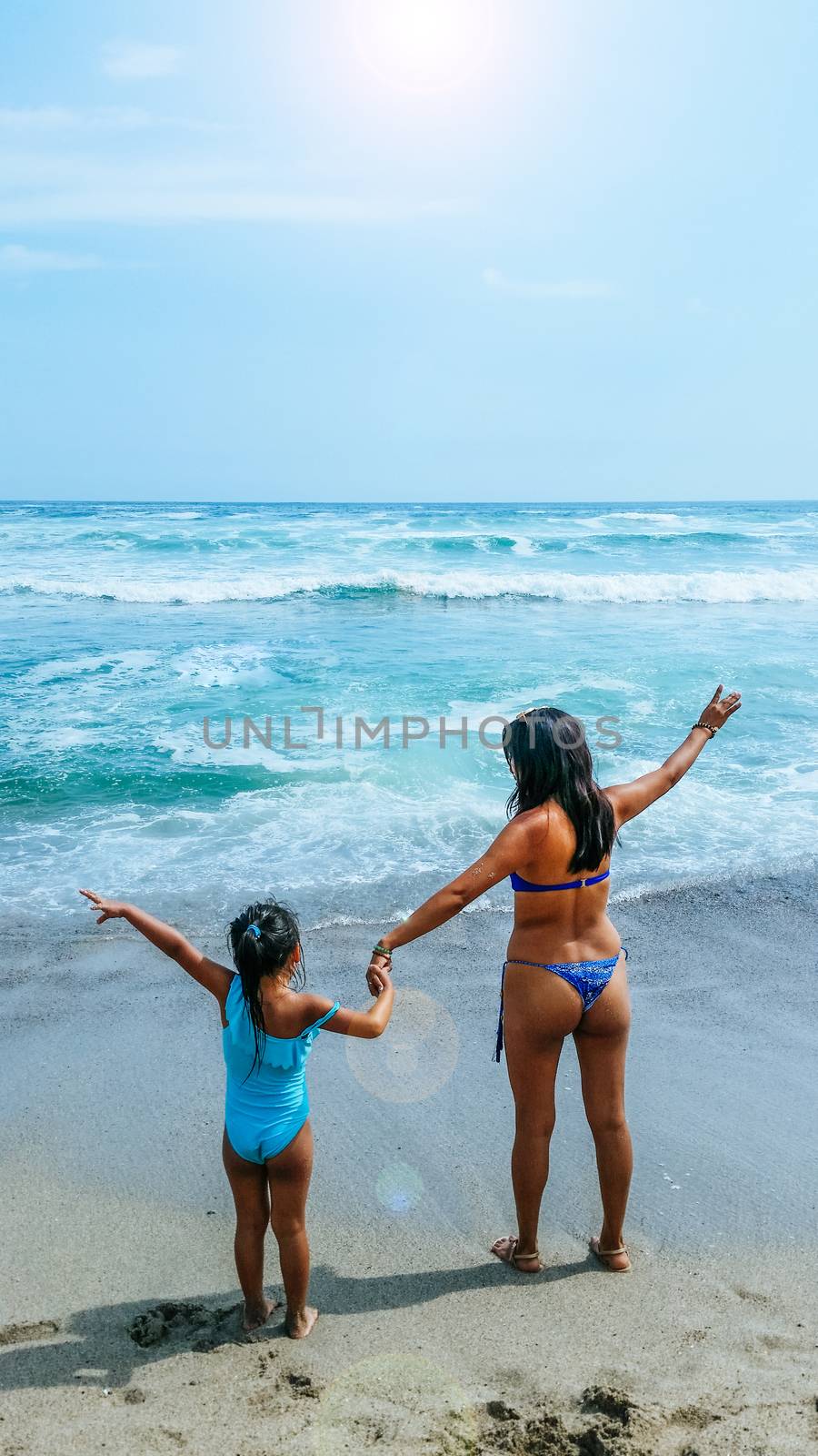 Mom and daughter are resting on the beach.