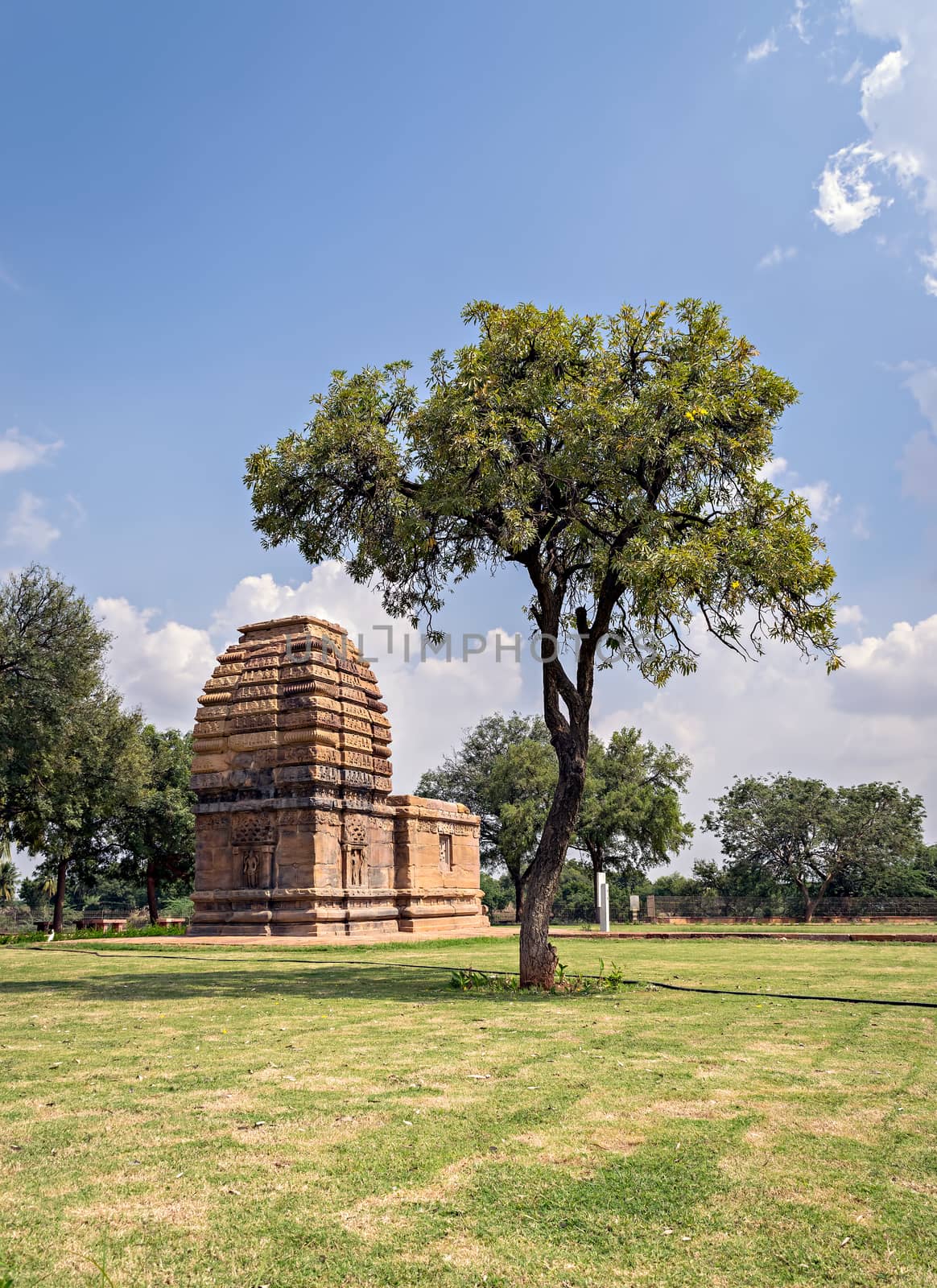 Ancient stone temple monument & tree at Pattadakal , Karnataka, India. by lalam