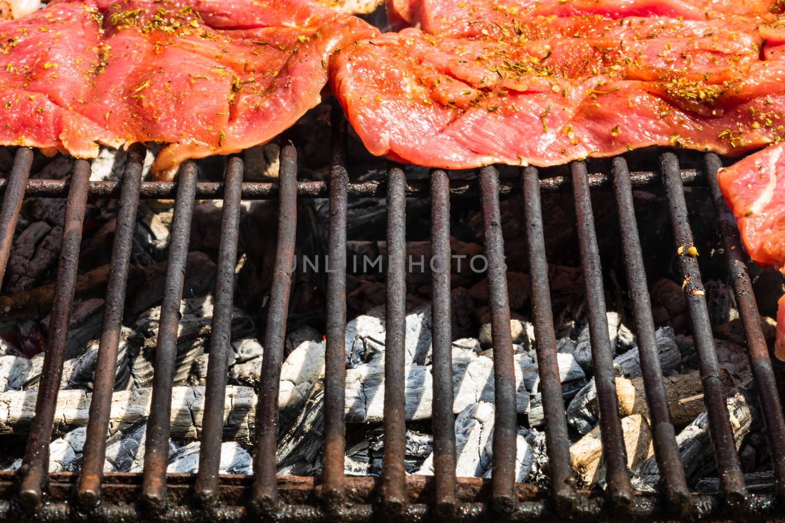 Close up of pork steak grilled on a charcoal barbeque isolated.