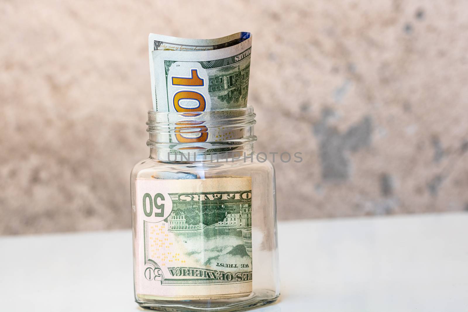 Composition with saving money banknotes in a glass jar. Concept  by vladispas