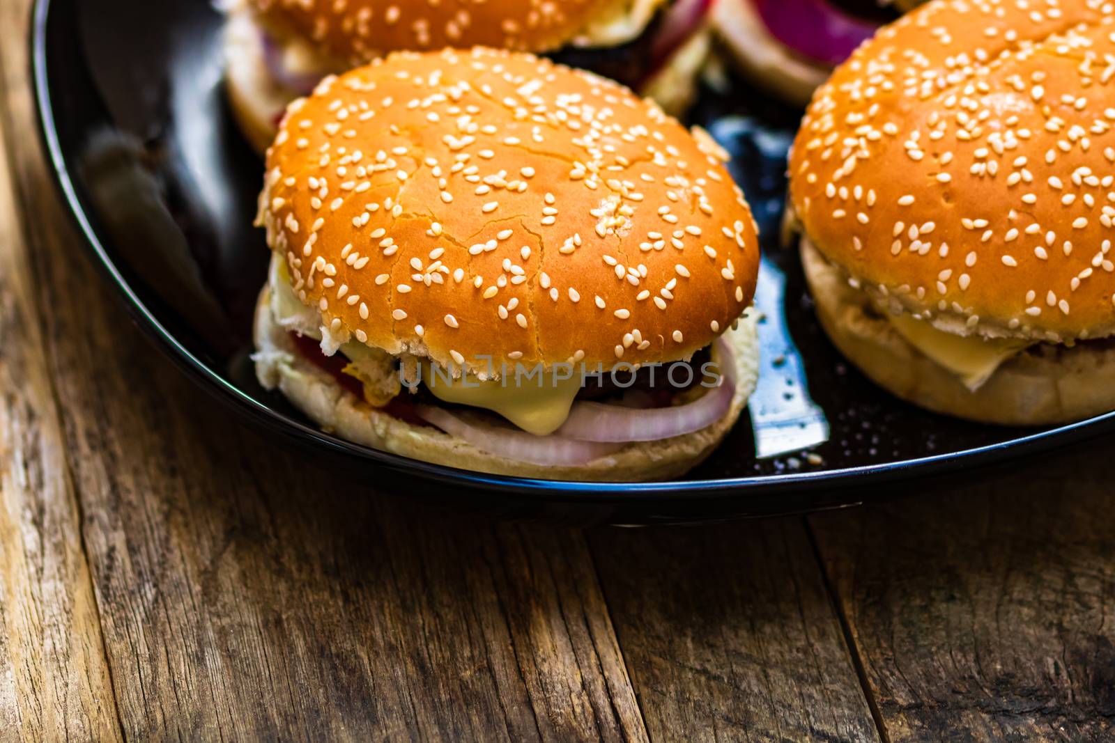 Closeup of fresh homemade tasty burgers on wooden table by vladispas