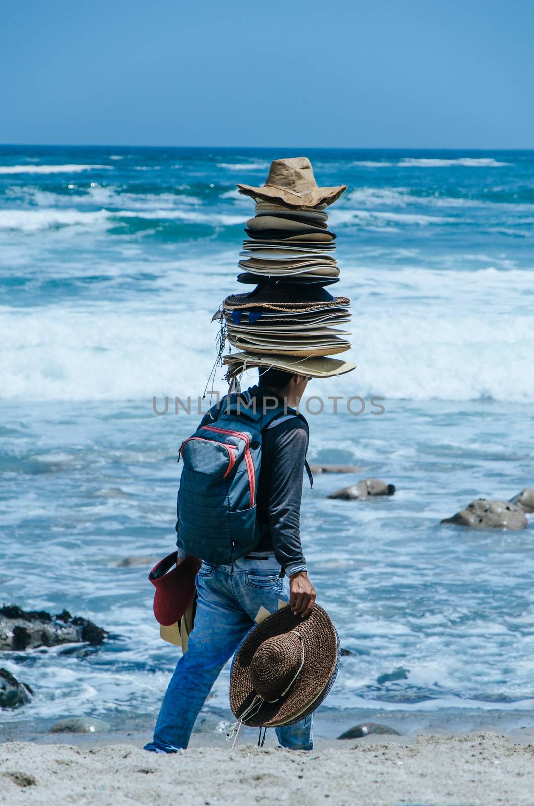 Seller of hats with many hats on his head, on a beach in Lima - Peru