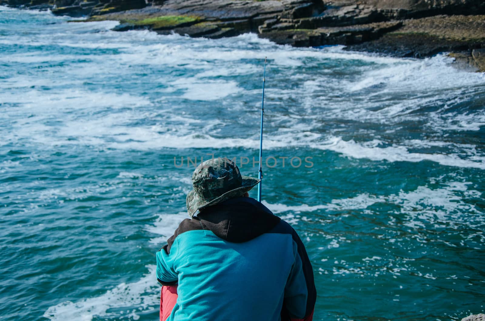 Fisherman on the seashore with his fishing rod