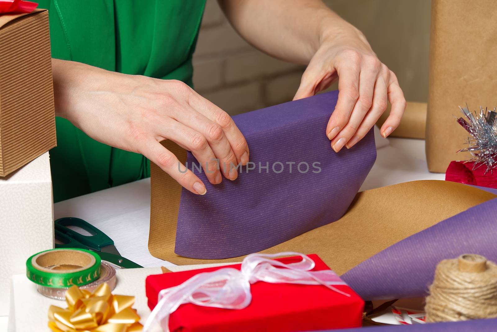 Gift wrapping for Christmas and New Year. Handmade. woman hands with gift ribbon, twine, tape and present wrapped