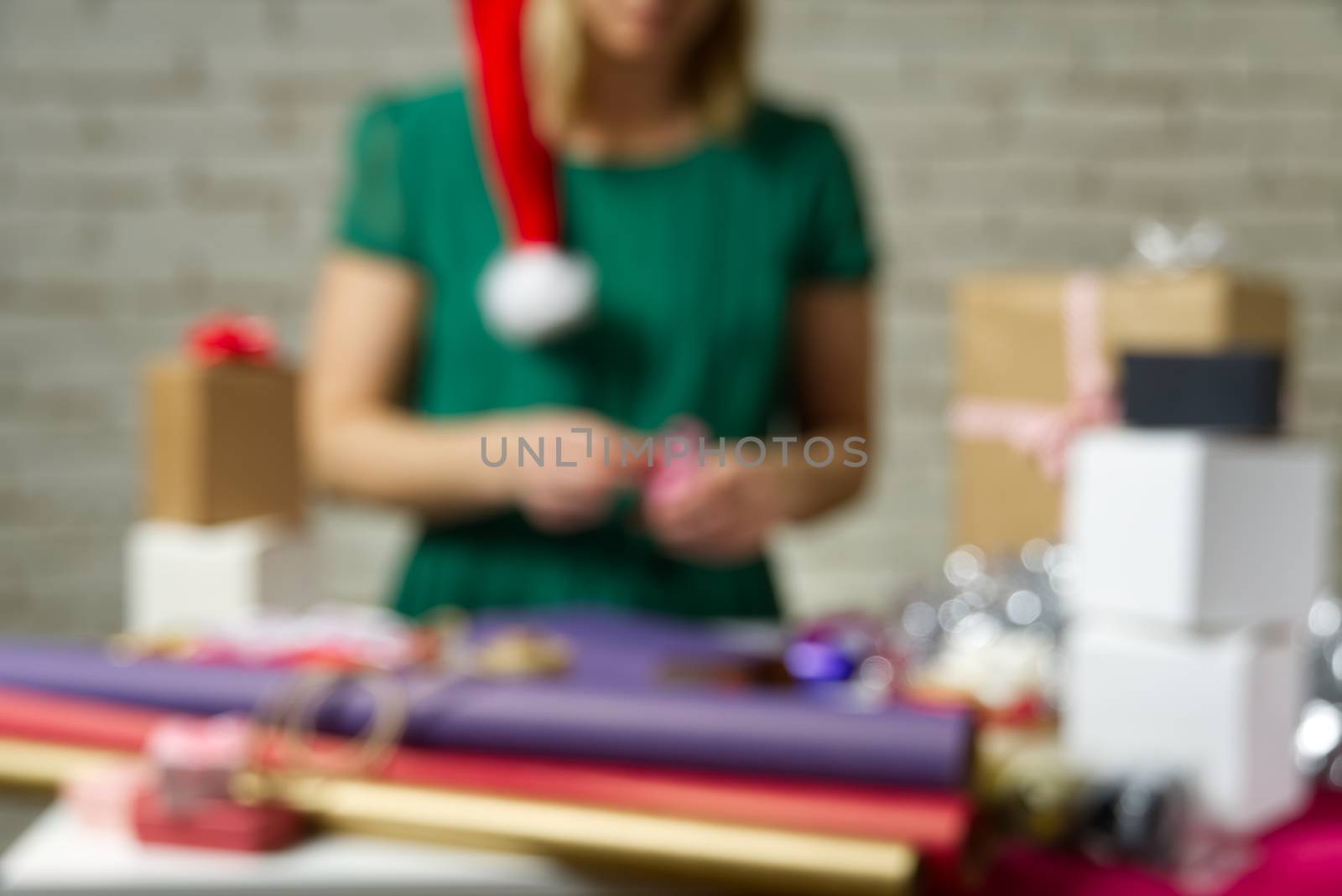 Defocused background. Gift wrapping for Christmas and New Year. Handmade. girl's hands with gift ribbon, twine, tape and present wrapped concept