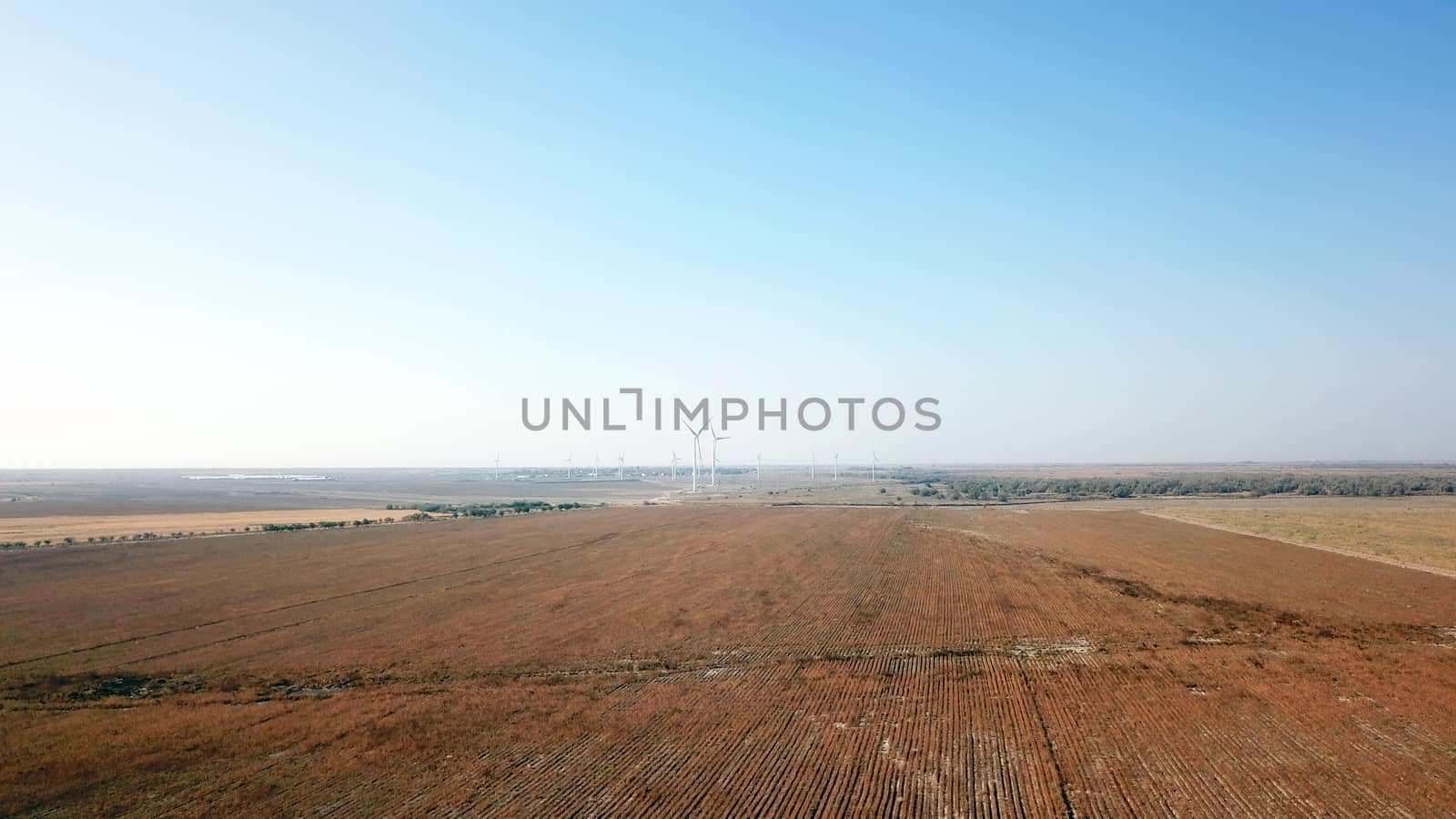 Windmills near the field. Top view from a drone. by Passcal