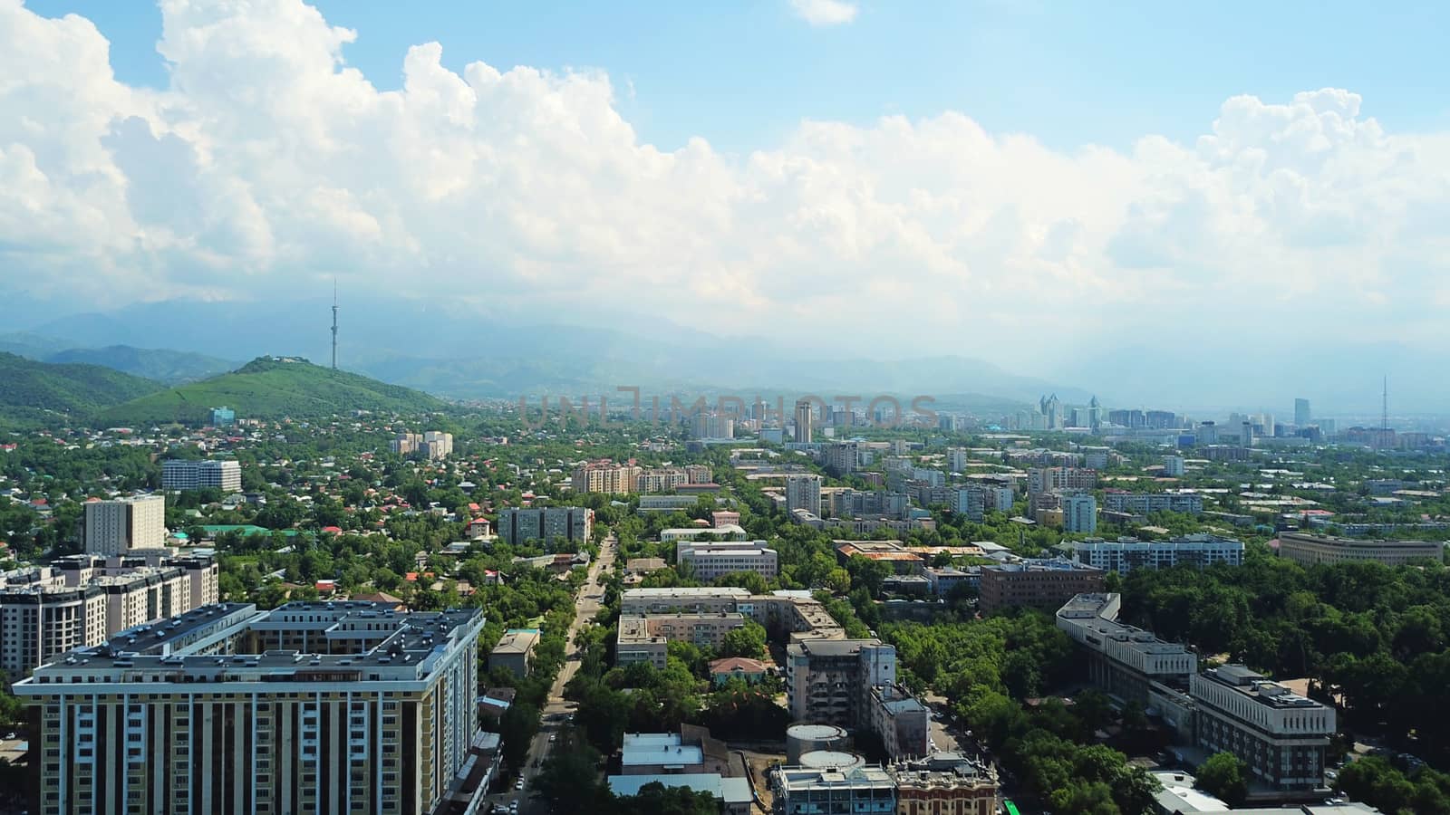 View of Almaty city with white clouds and blue sky by Passcal