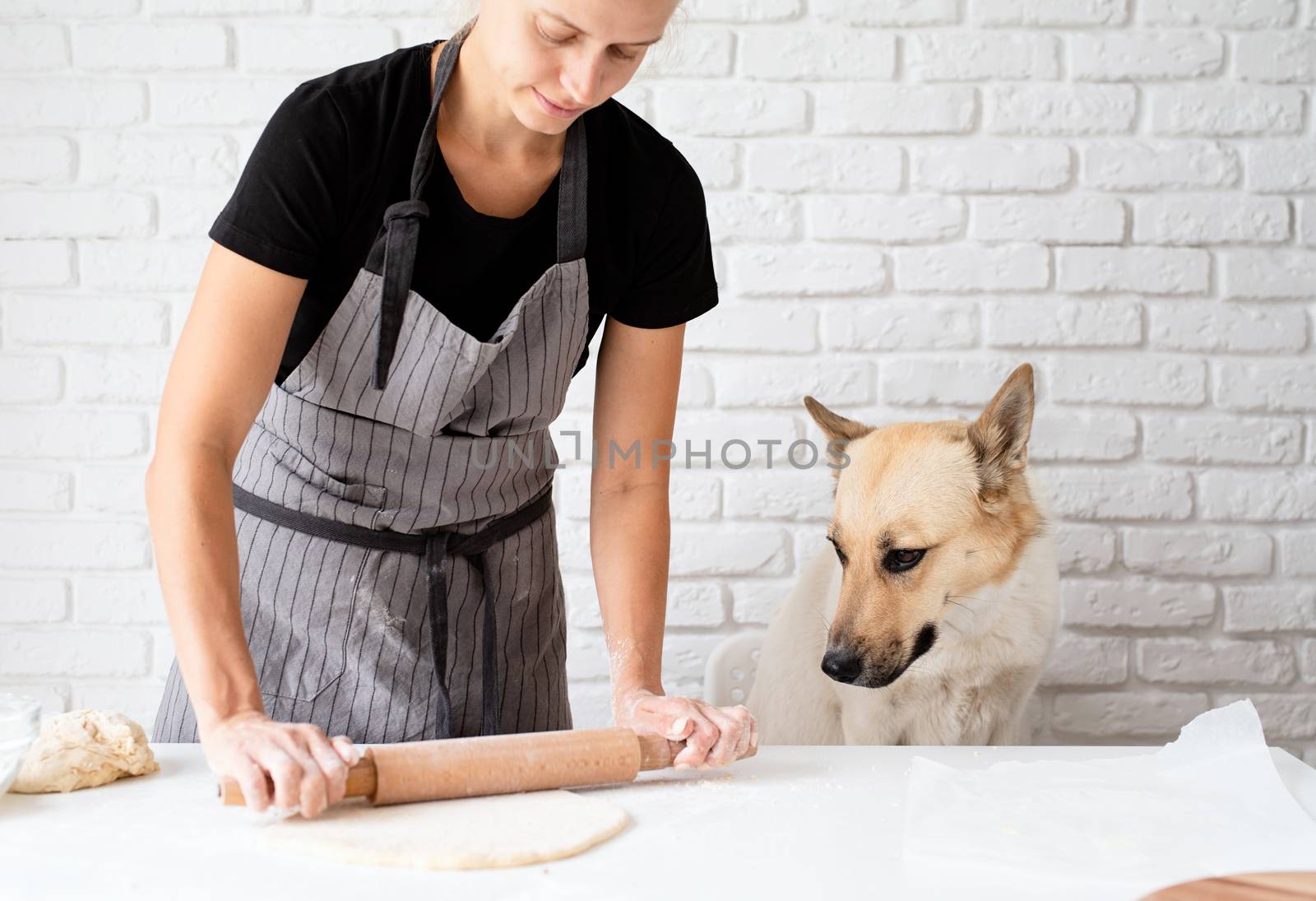 Woman kneading dough at home by Desperada