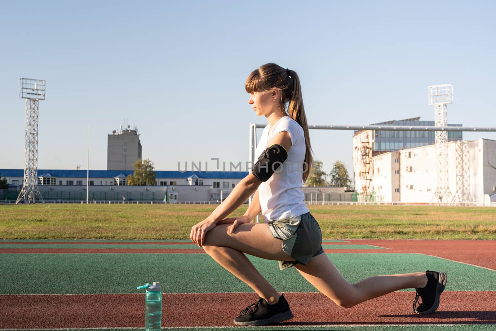 Teenager girl doing stretching at the stadium by Desperada