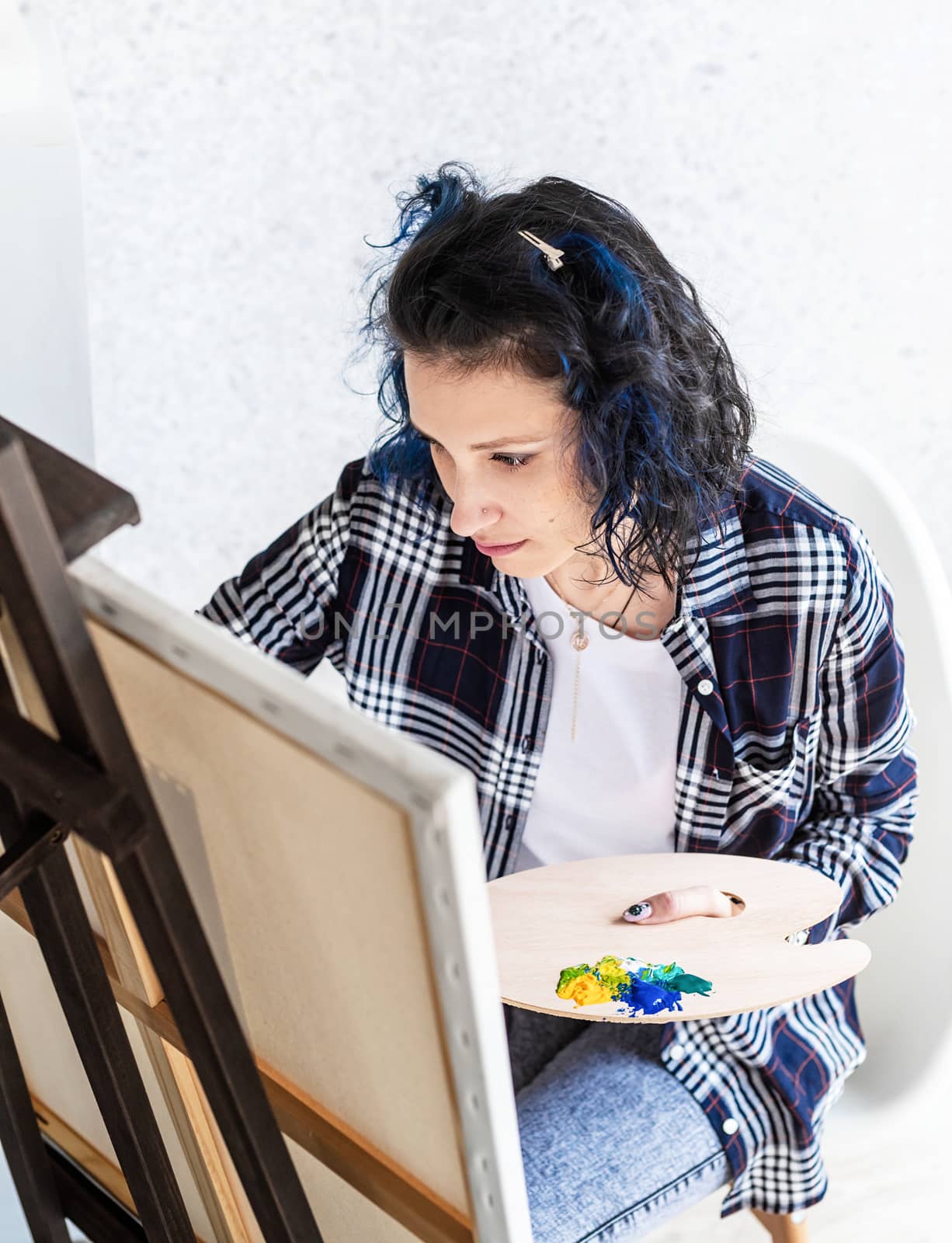 Creative woman artist painting a picture working in her studio