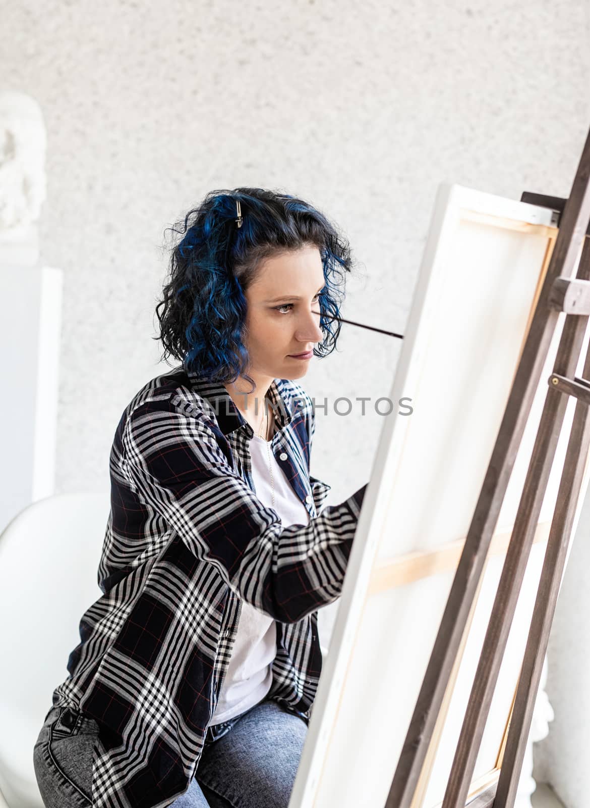 Creative woman artist painting a picture working in her studio