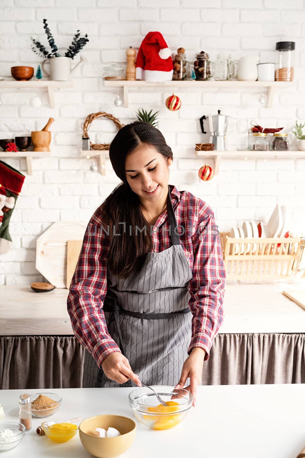 Cooking and baking. Young latin woman whisking eggs cooking at the kitchen