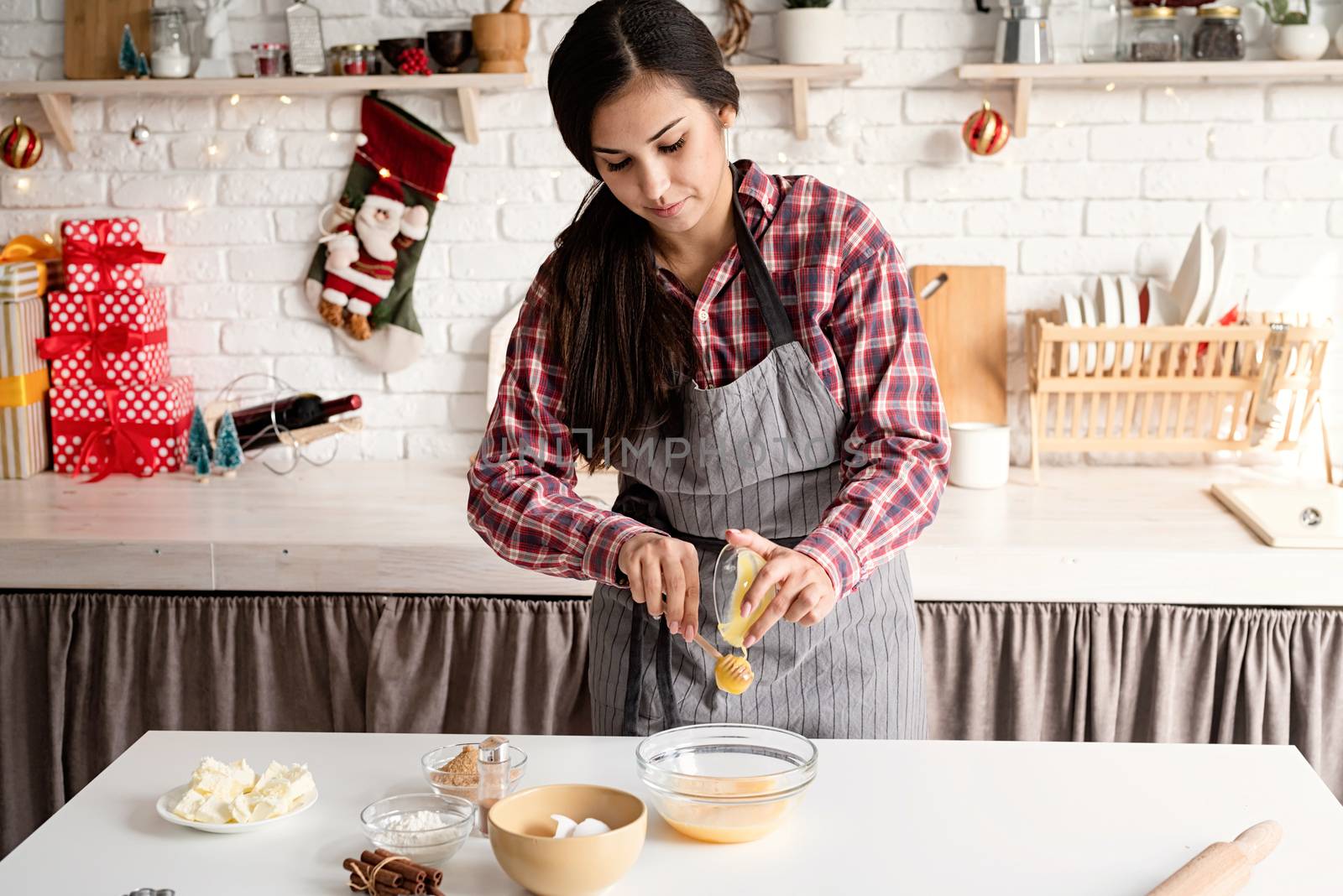 Cooking and baking. Young latin woman pouring the honey to the dough cooking at the kitchen