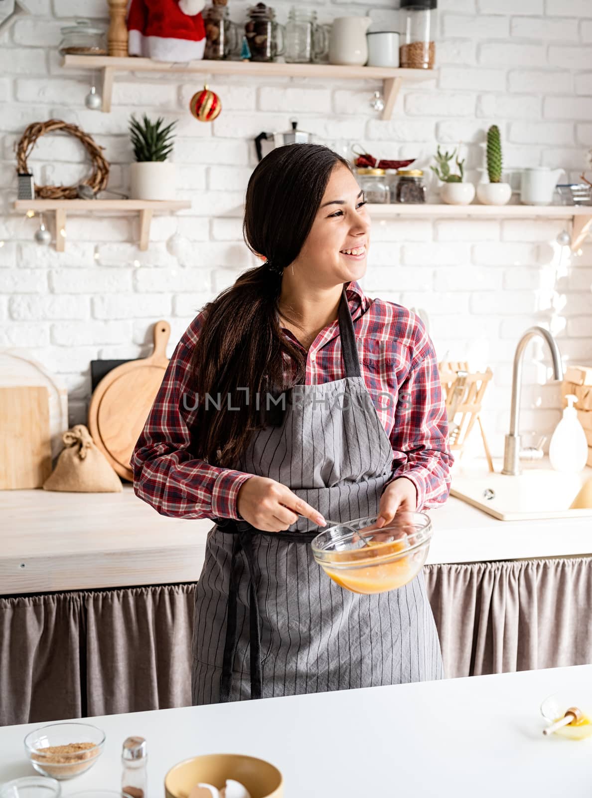 Cooking and baking. Young latin woman whisking eggs cooking at the kitchen