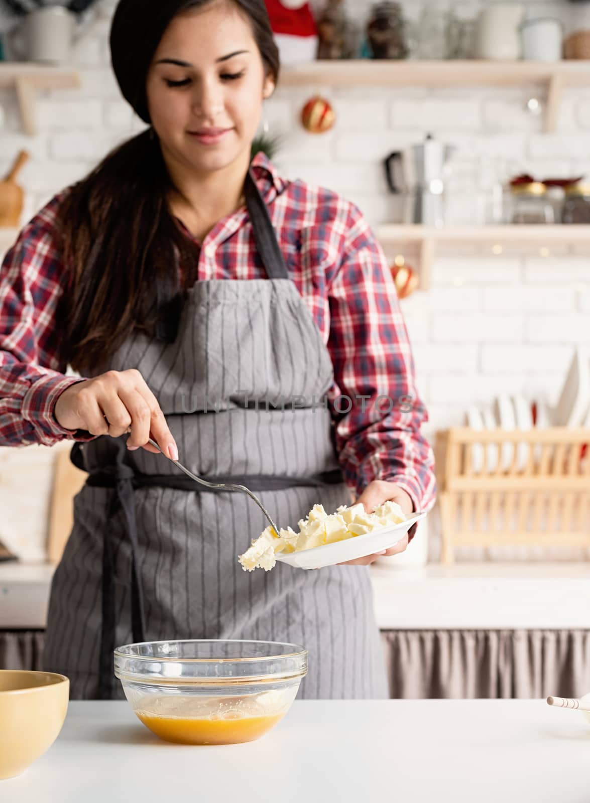 Young latin woman cooking at the kitchen by Desperada